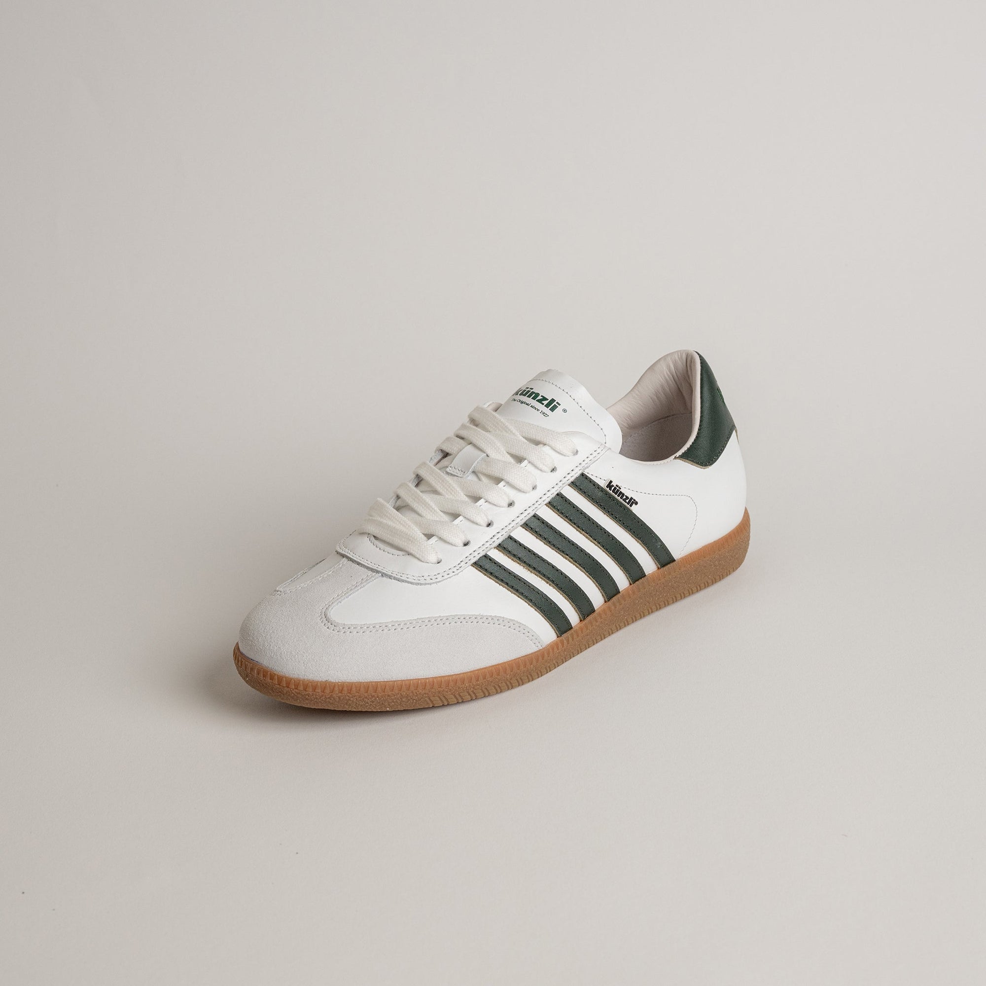Weiß-grüner Kuenzli Schuhe Sneaker mit Streifen und brauner Sohle auf neutralem Hintergrund.