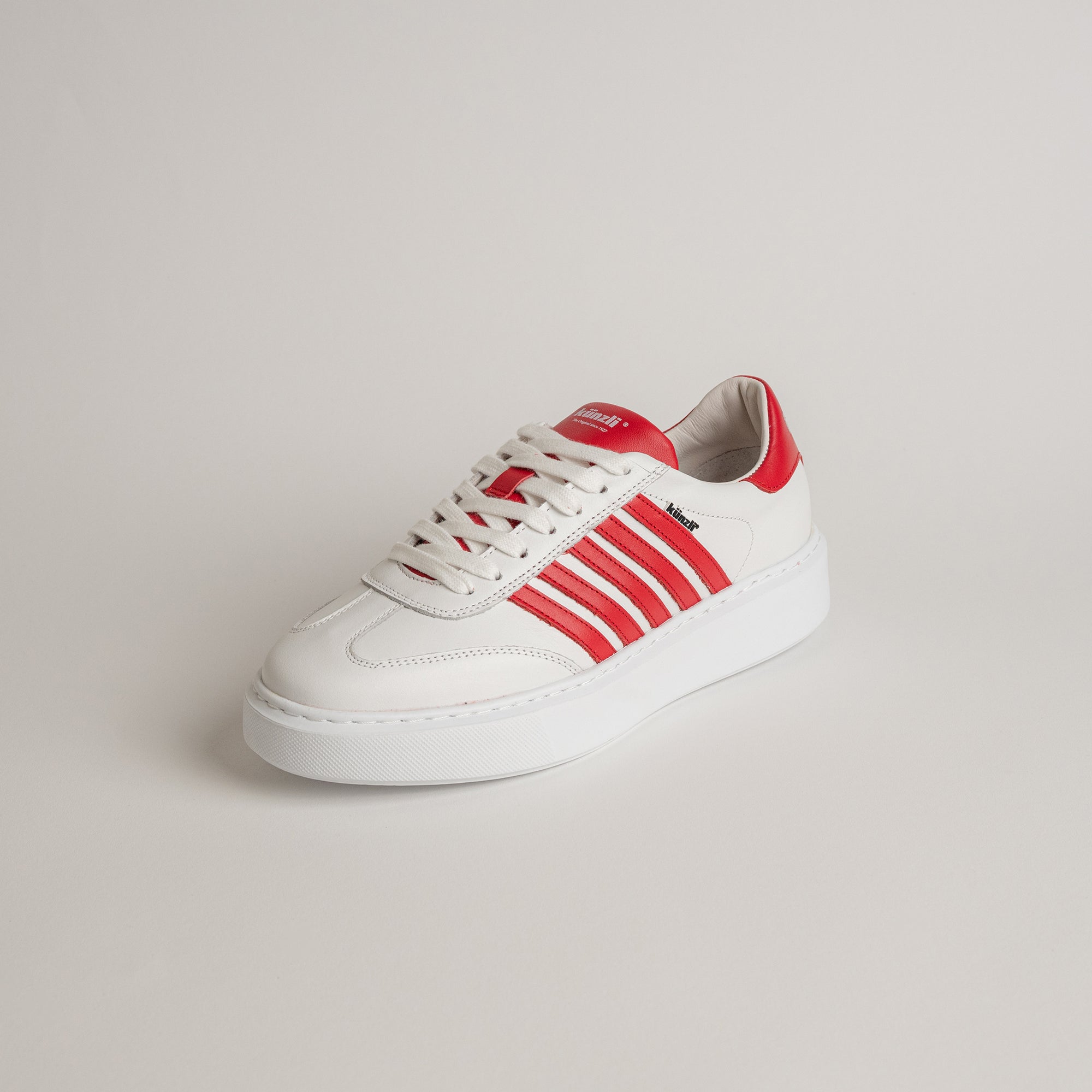 Weißer Sneaker mit roten Streifen von Kuenzli Schuhe auf hellem Hintergrund.