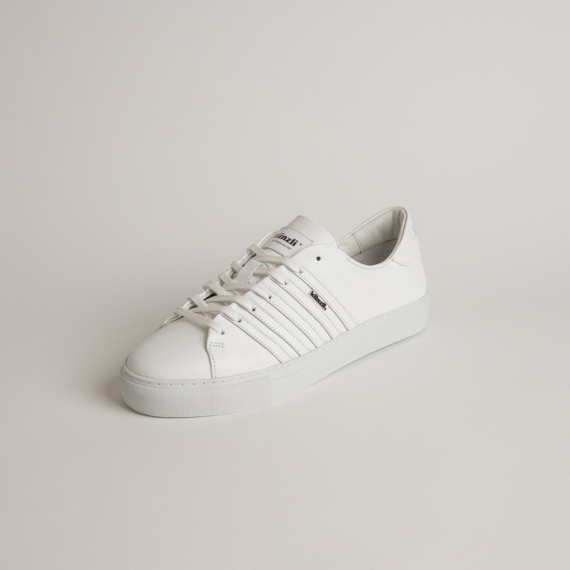 Weißer Ledersneaker von Kuenzli Schuhe auf neutralem Hintergrund, stilvoll und modern.