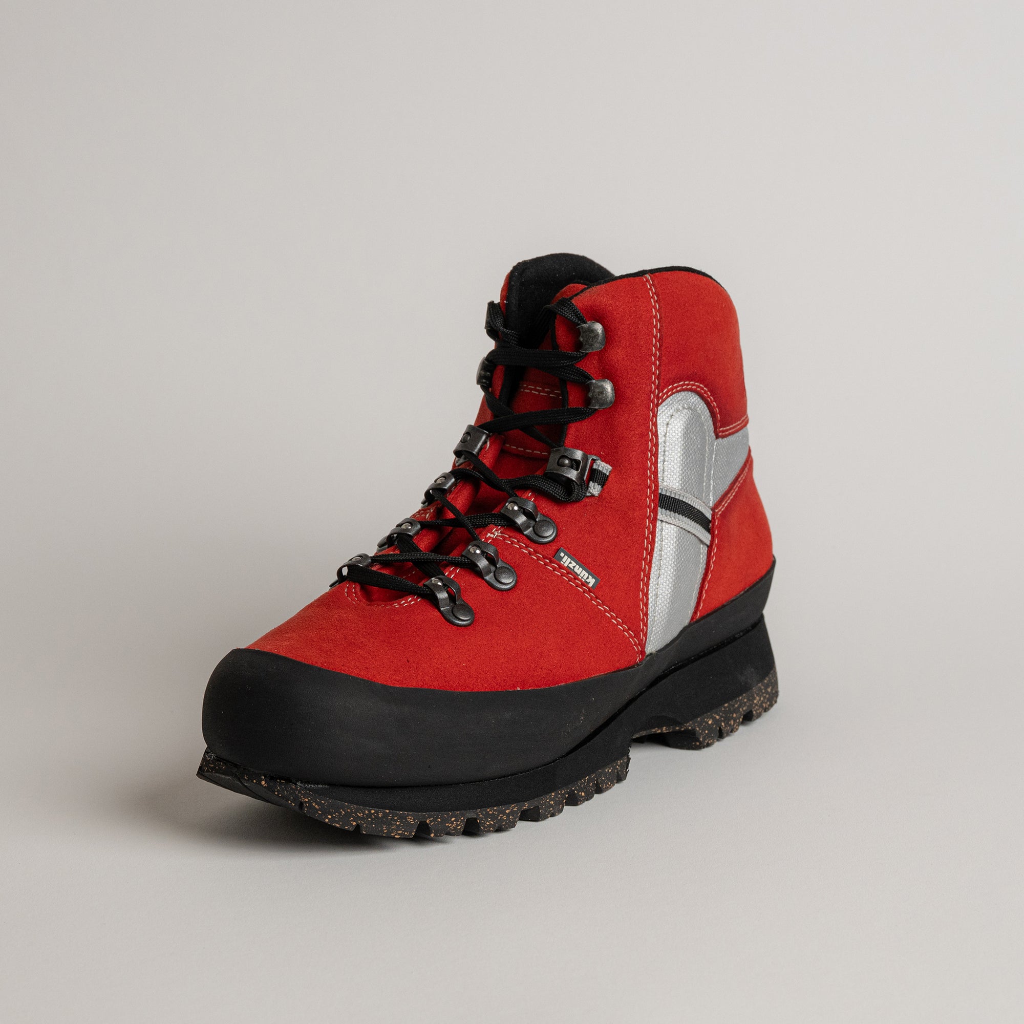 Roter Wanderstiefel von Kuenzli Schuhe mit schwarzer Sohle und silbernen Details.