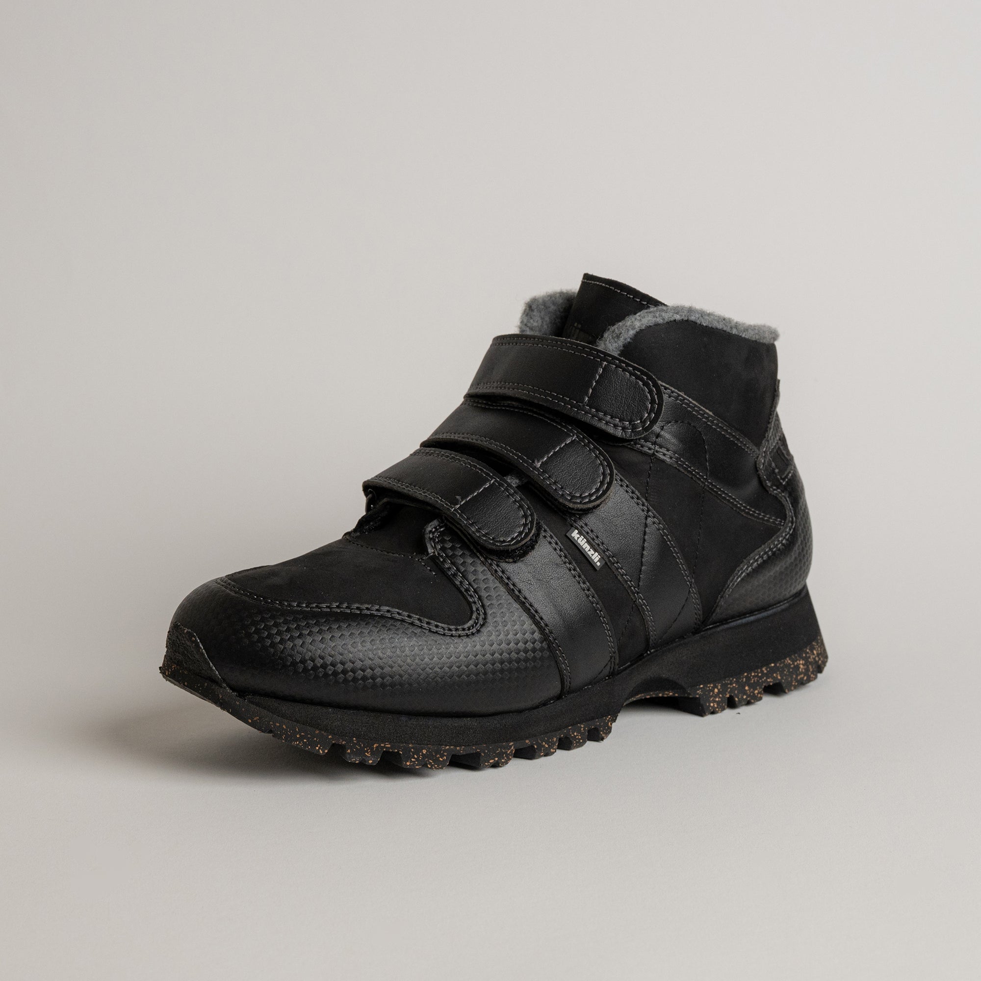 Schwarzer Kuenzli Schuh mit Klettverschluss und robustem Profil für Outdoor-Aktivitäten.