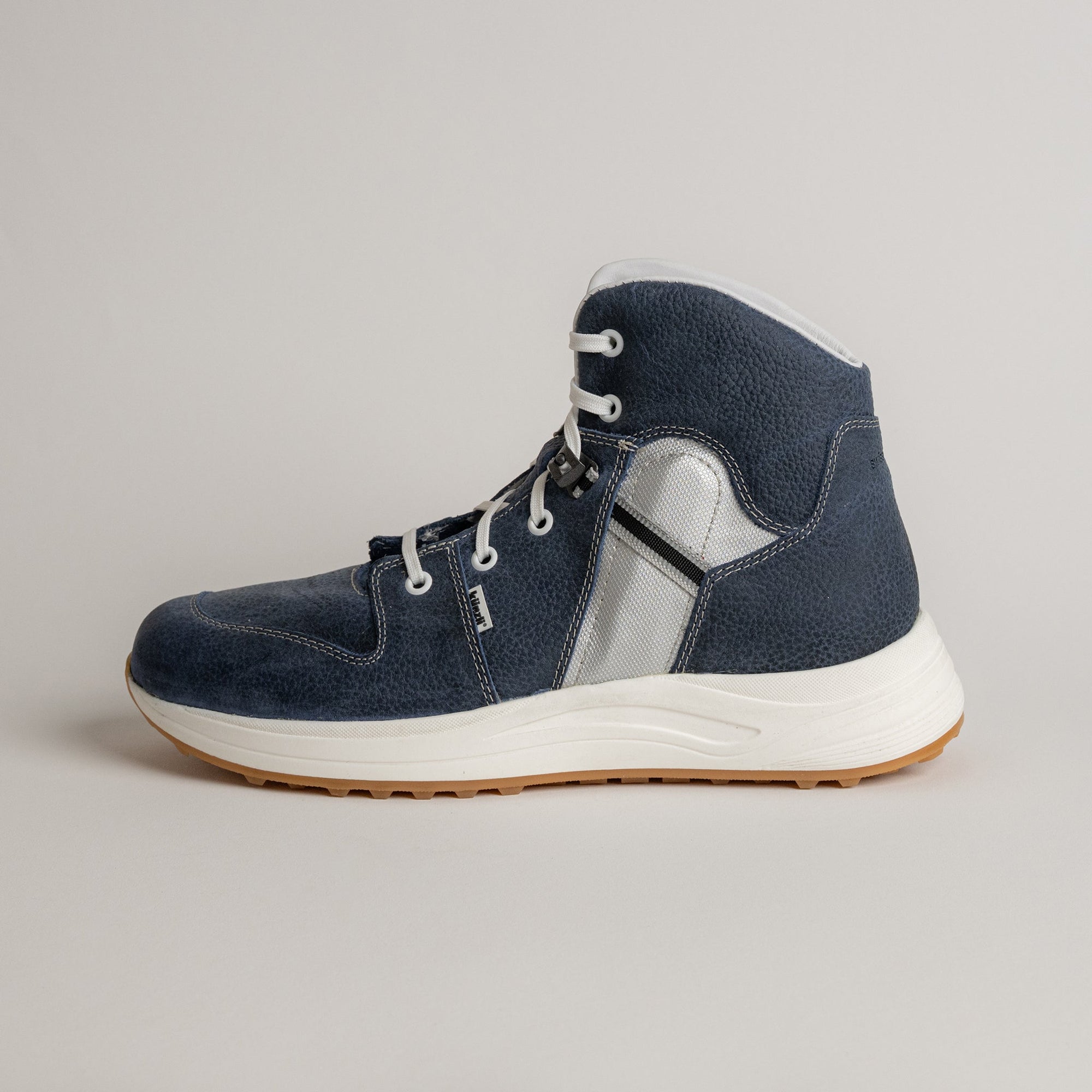 Ein blauer Kuenzli Schuhe Sneaker mit weißer Sohle und silbernen Details.