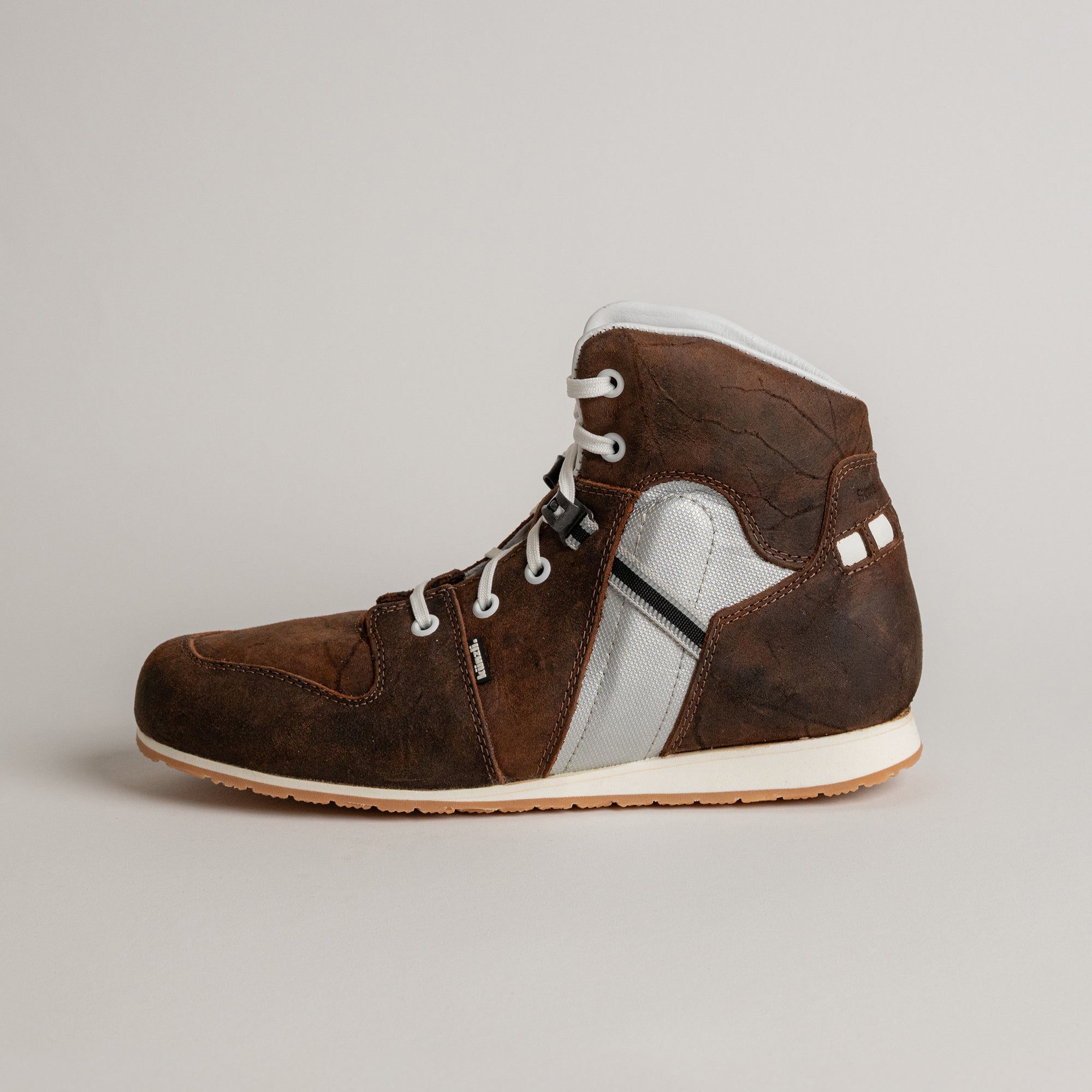 Brauner Lederschuh von Kuenzli Schuhe mit weißer Sohle und Schnürsenkeln.