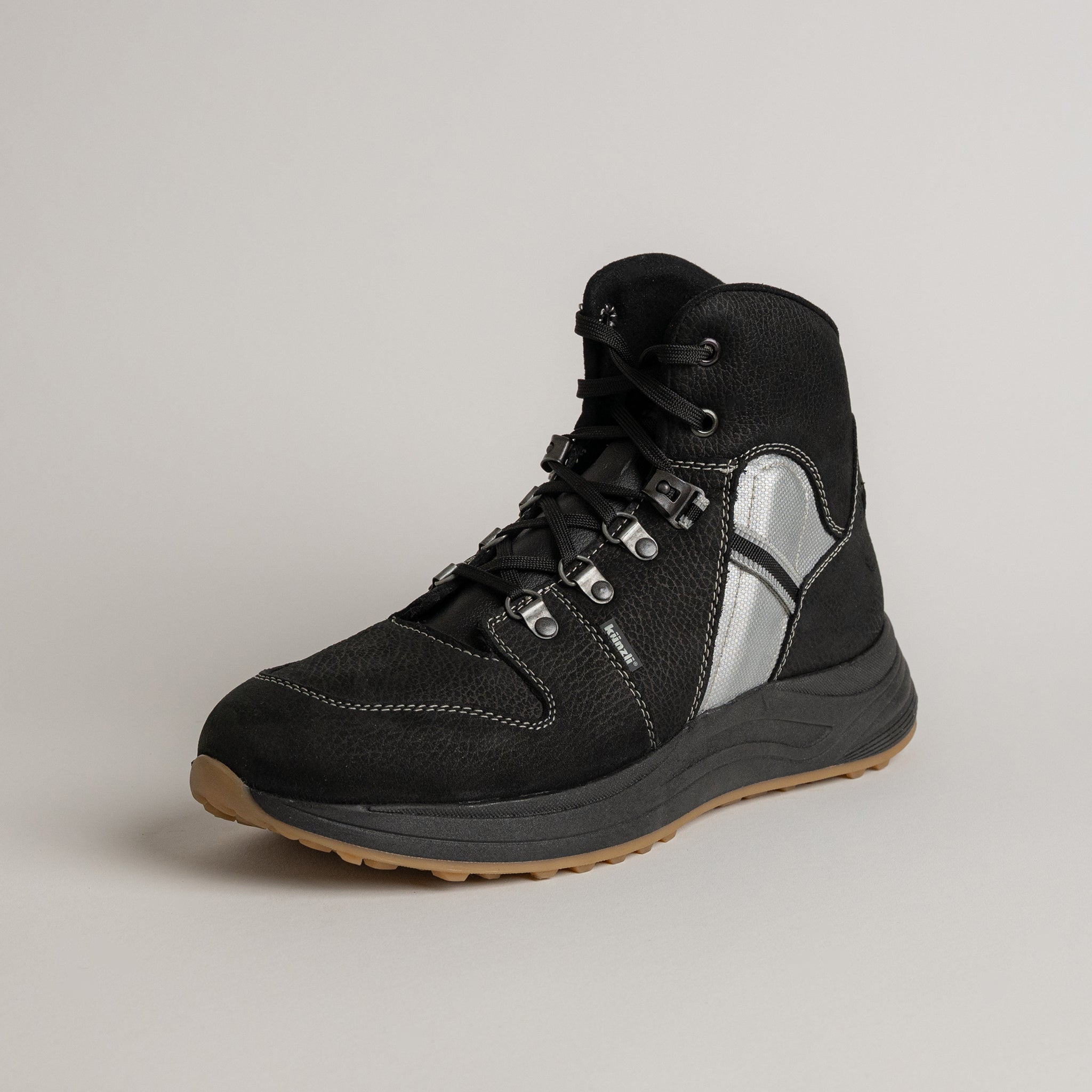 Schwarzer Wanderschuh von Kuenzli Schuhe mit robustem Design und reflektierenden Details.