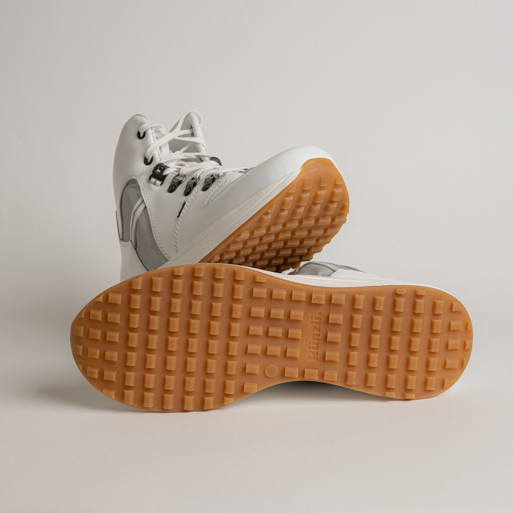 Weiße Kuenzli Schuhe mit rutschfester, brauner Sohle auf hellem Hintergrund.