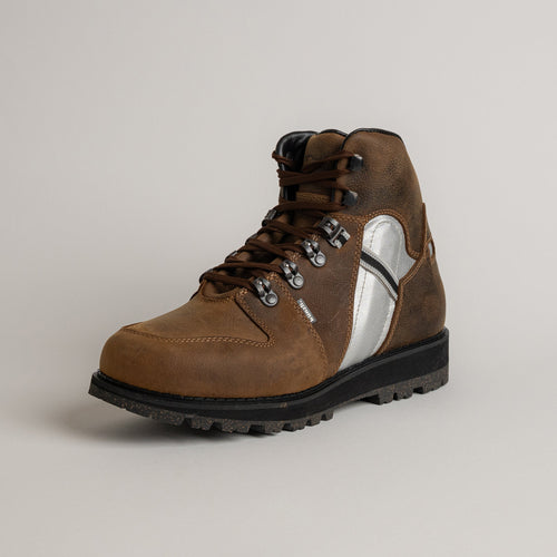 Ein brauner Lederstiefel von Kuenzli Schuhe mit robustem Design und silbernen Details.