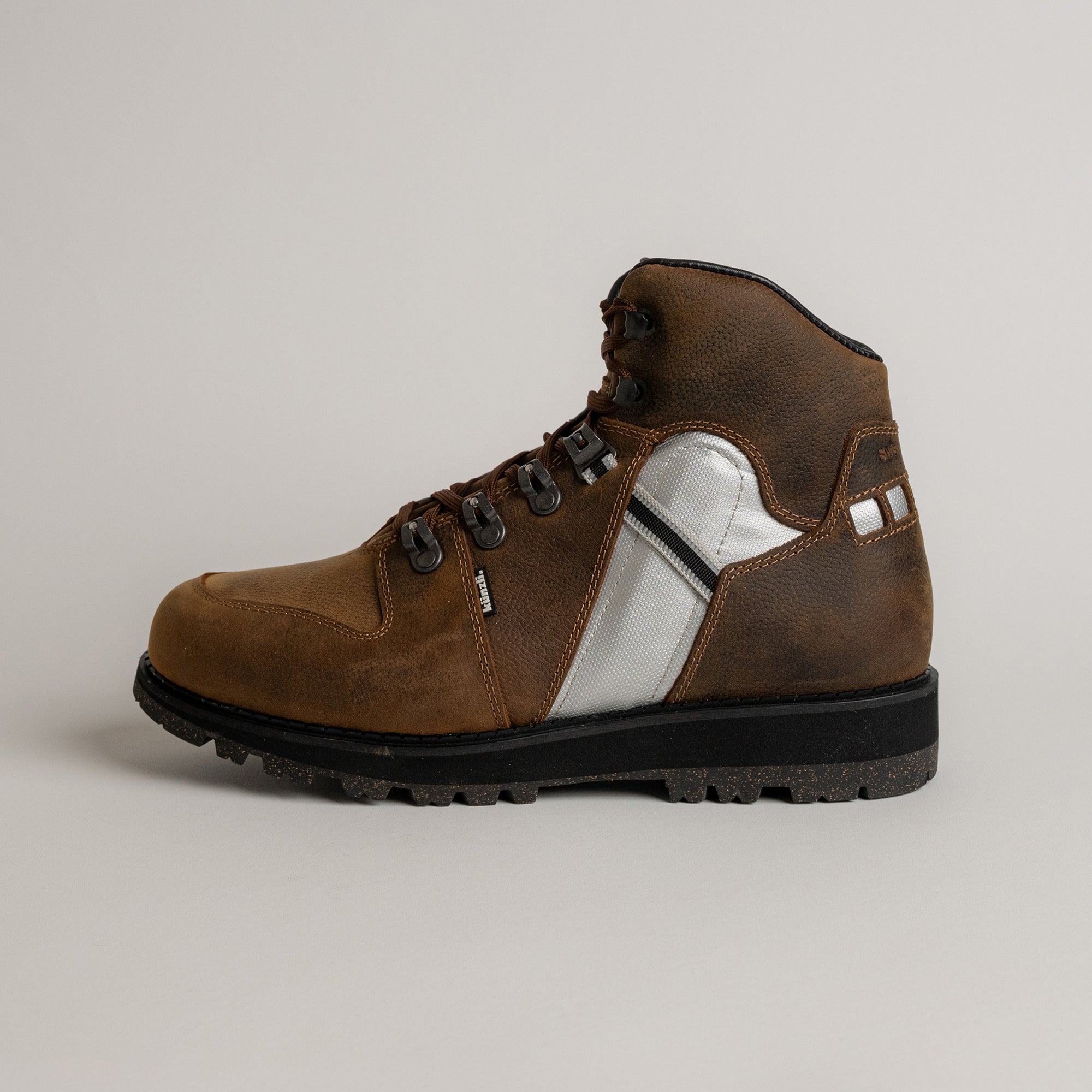 Brauner Lederstiefel von Kuenzli Schuhe mit robustem Profil und silbernen Details.