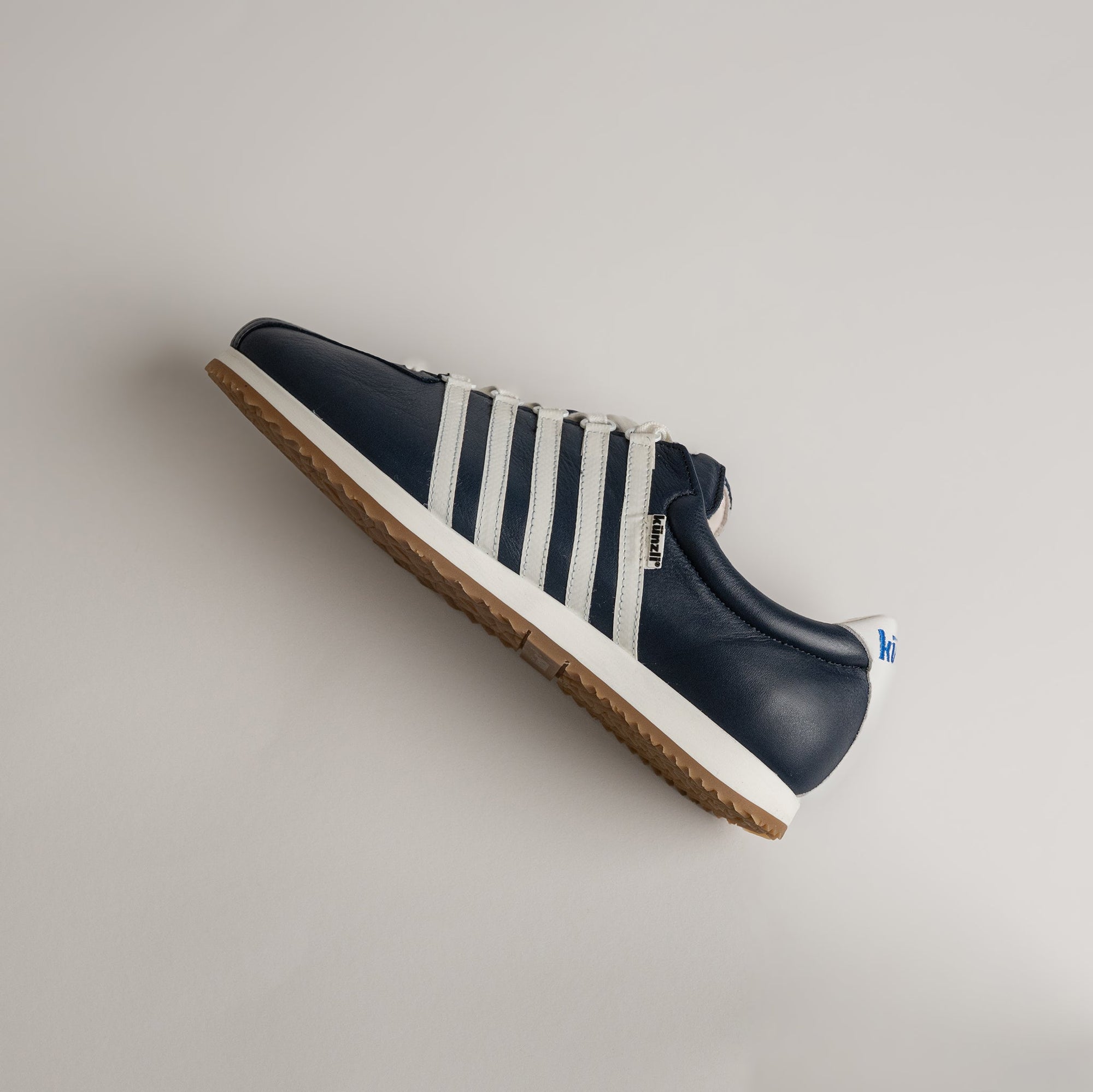 Ein blauer und weißer Kuenzli Schuhe Sneaker auf hellem Hintergrund.