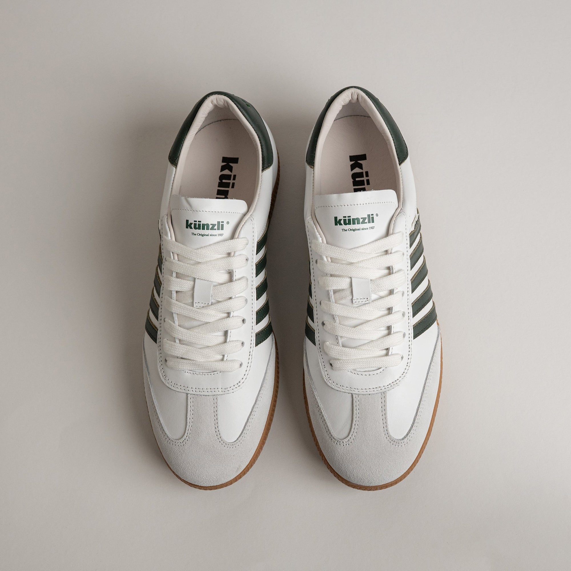 Weiße Kuenzli Schuhe mit grünen Streifen, ideal für sportliche Aktivitäten und Freizeit.