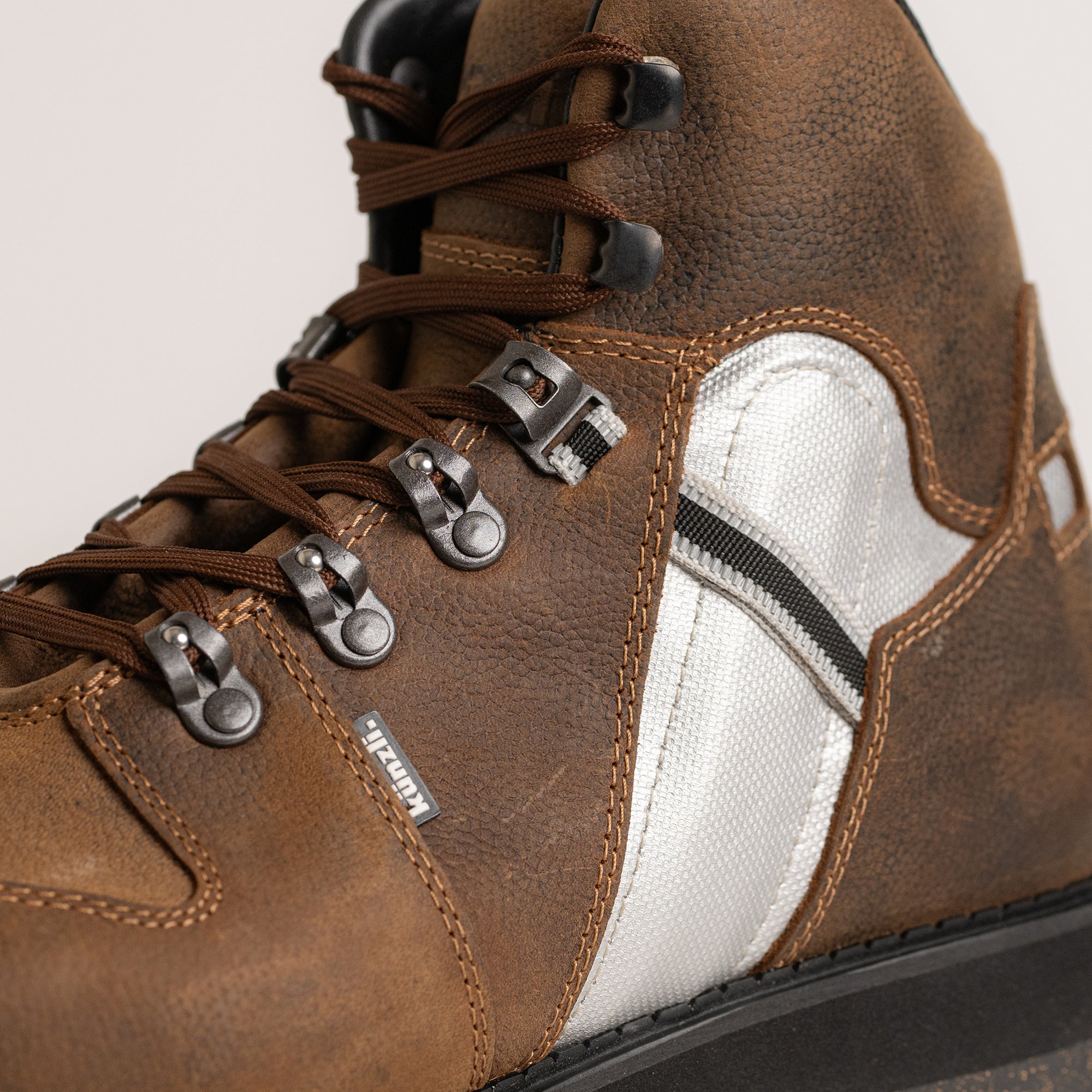 Brauner Lederstiefel von Kuenzli Schuhe mit robusten Schnürsenkeln und silbernen Details.