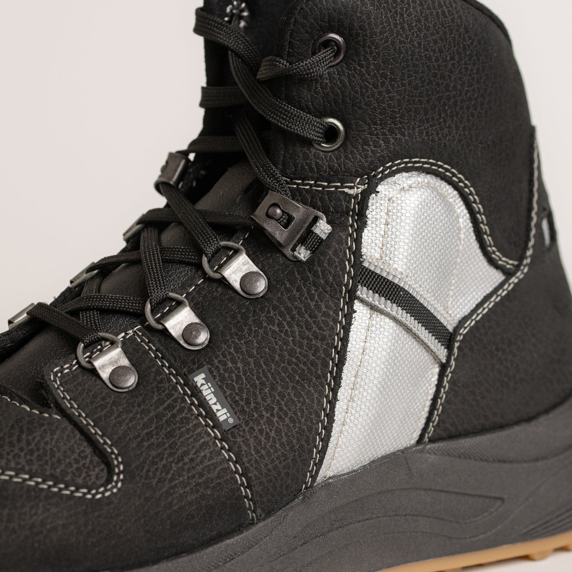 Schwarzer Kuenzli Schuhe Stiefel mit silbernen Details und robusten Schnürsenkeln.