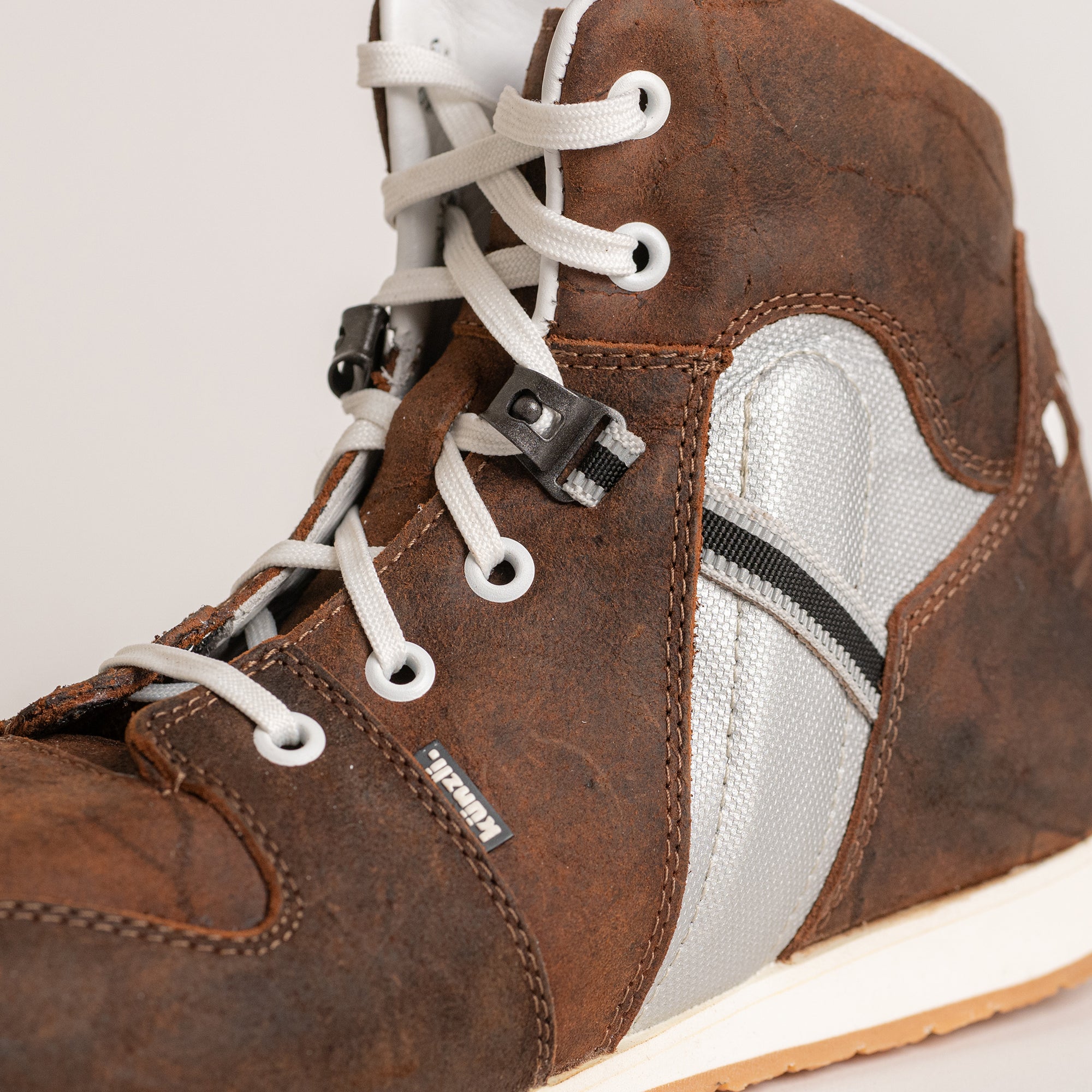 Brauner Lederstiefel von Kuenzli Schuhe mit weißen Schnürsenkeln und robustem Design.