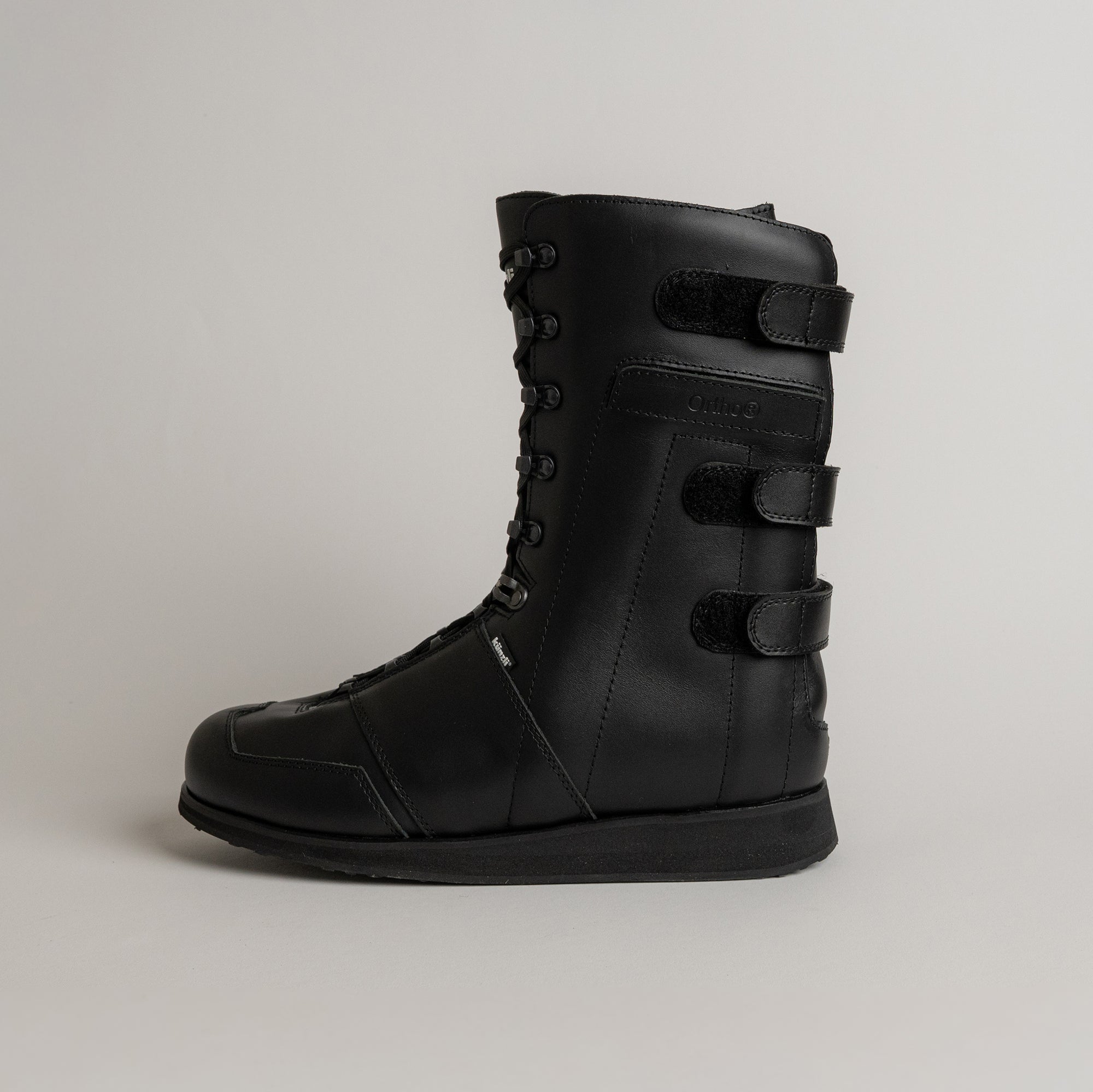 Schwarzer Lederstiefel von Kuenzli Schuhe mit Schnürung und Klettverschluss, seitlich fotografiert.