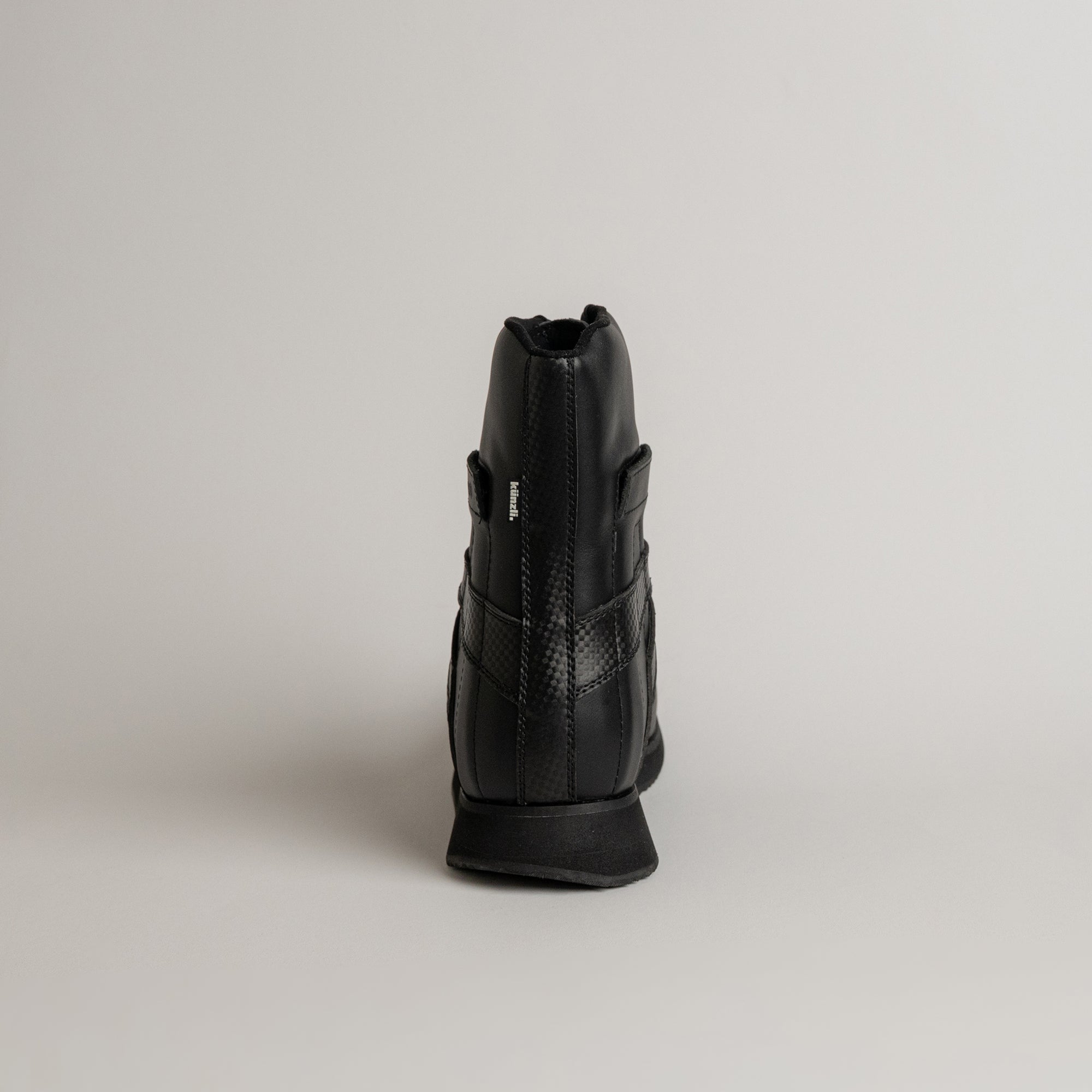 Schwarzer Lederschuh von Kuenzli Schuhe, Rückansicht, auf neutralem Hintergrund.