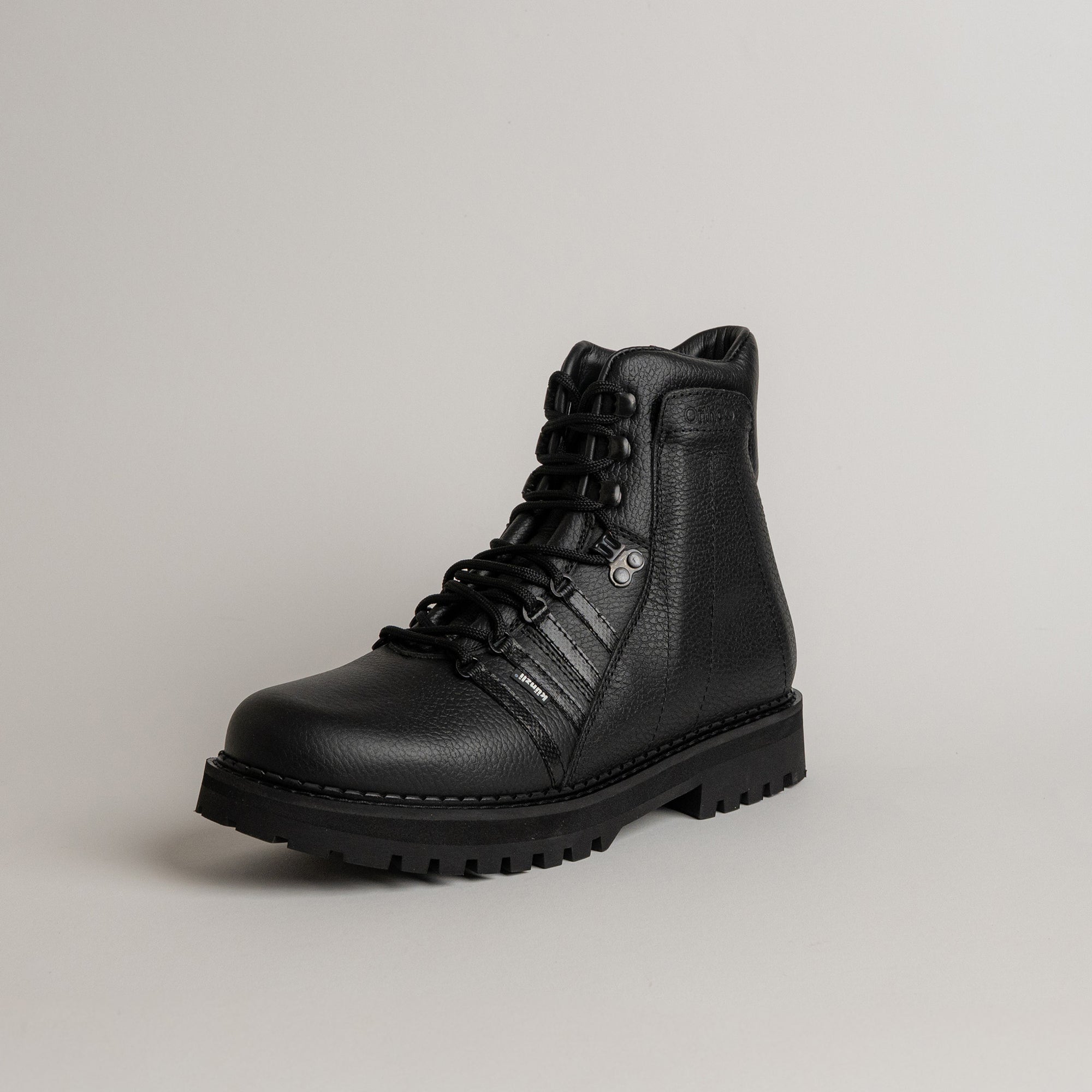 Schwarzer Lederstiefel von Kuenzli Schuhe mit robuster Sohle auf grauem Hintergrund.