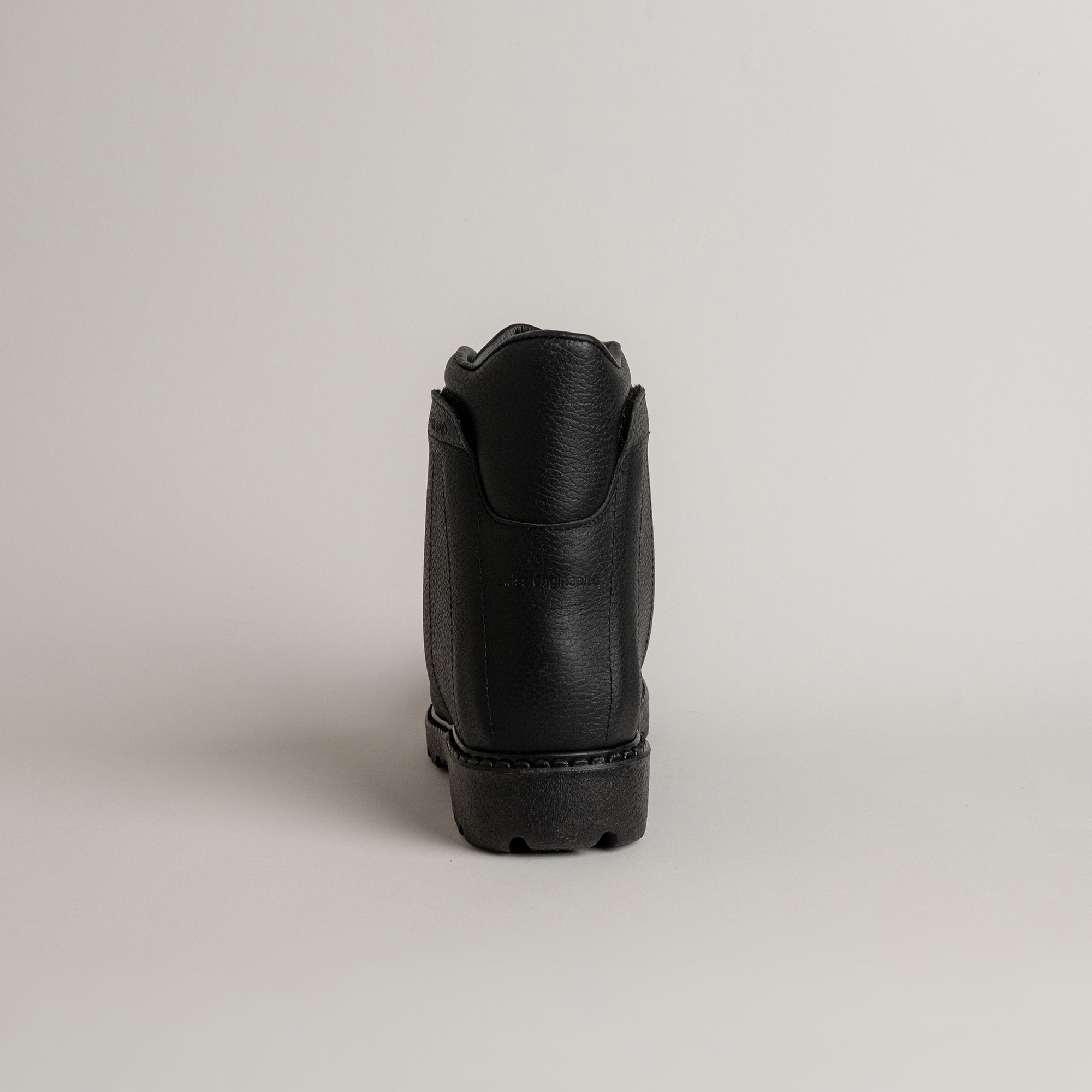 Schwarzer Lederschuh von Kuenzli Schuhe, Rückansicht, auf hellem Hintergrund präsentiert.