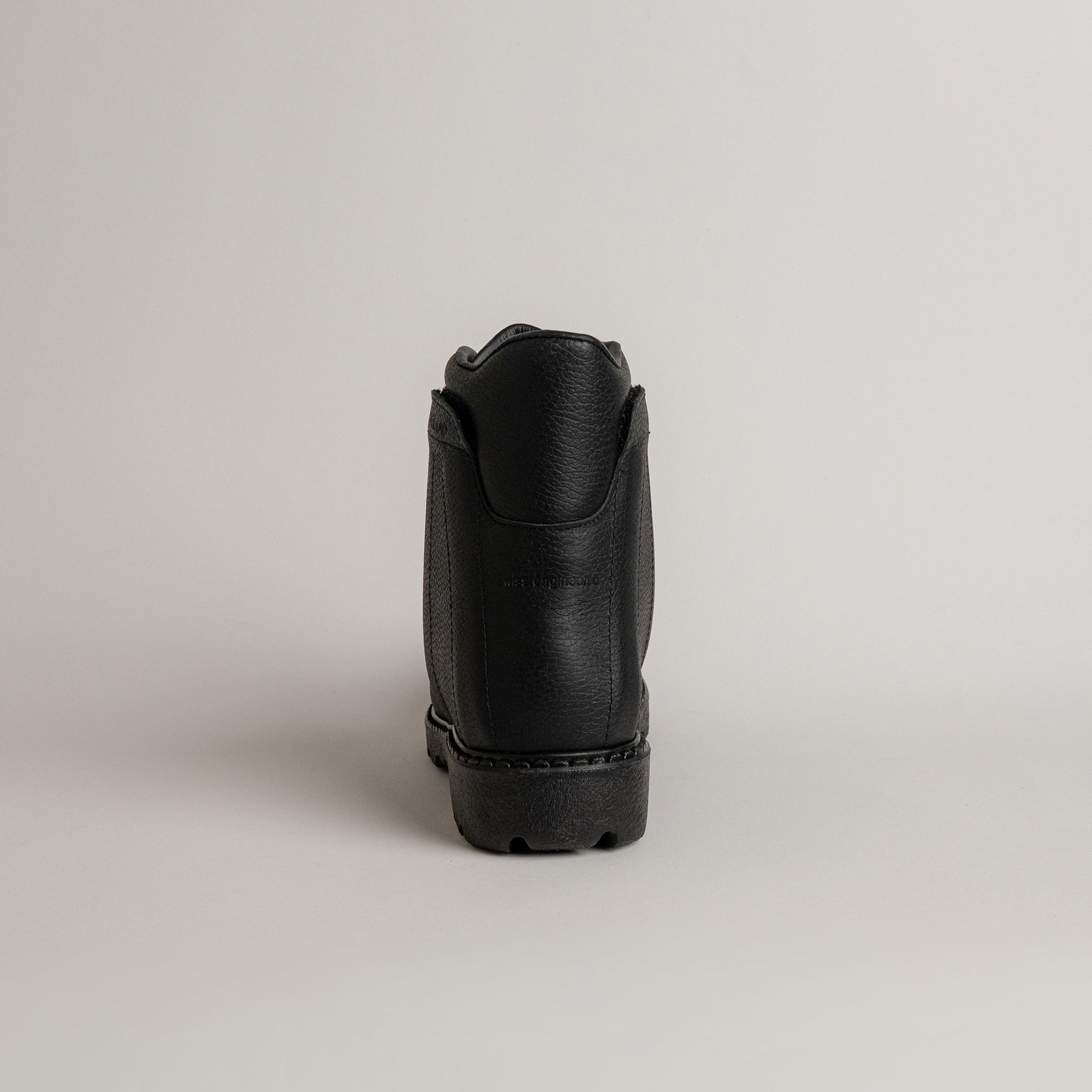 Schwarzer Lederschuh von Kuenzli Schuhe, Rückansicht, auf hellem Hintergrund.