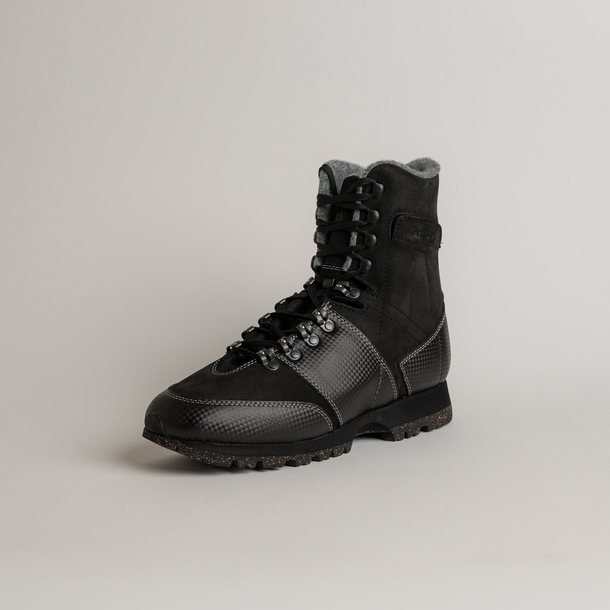 Schwarzer Lederstiefel von Kuenzli Schuhe mit robustem Design auf grauem Hintergrund.