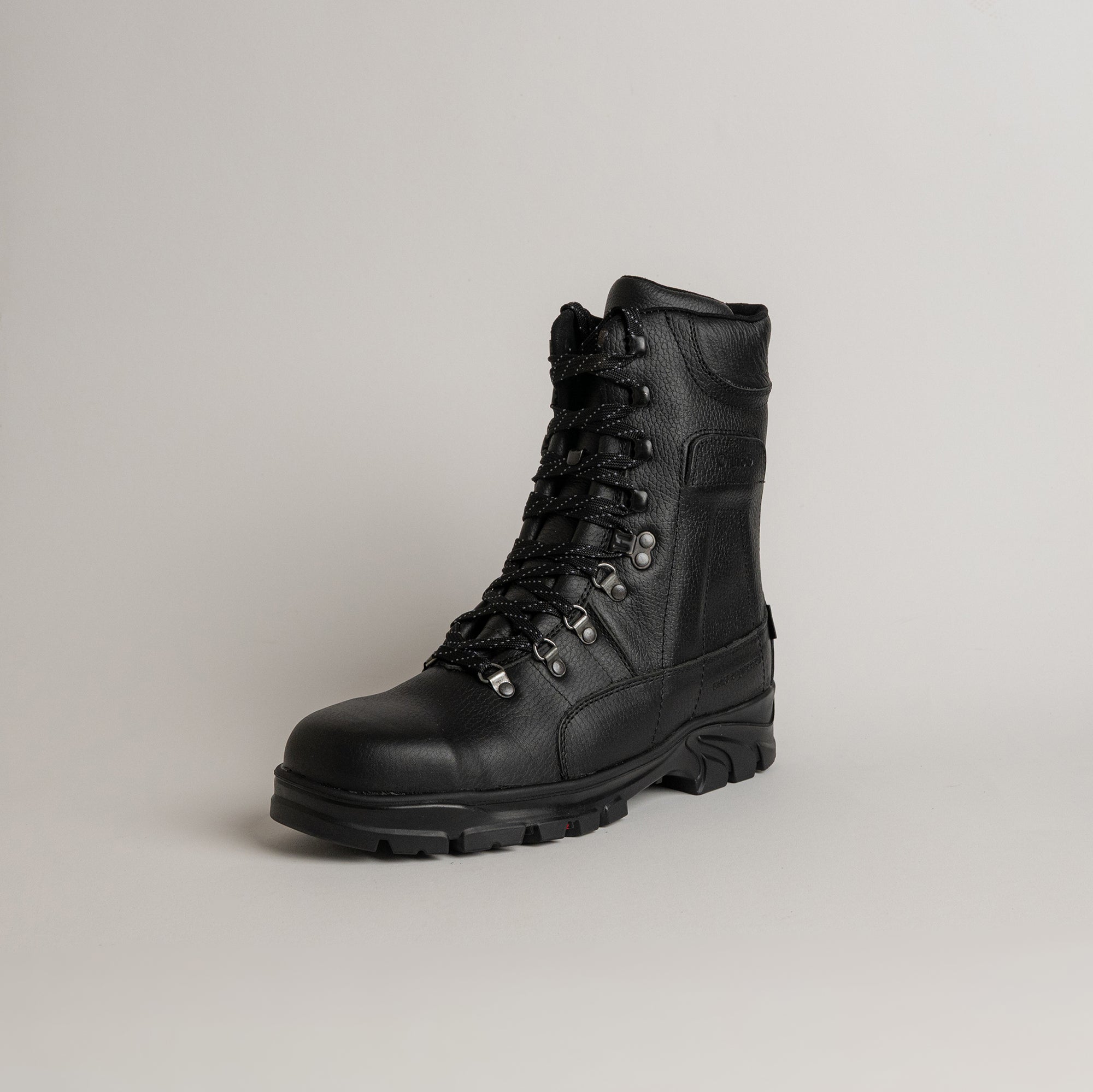 Schwarzer Lederstiefel von Kuenzli Schuhe mit robuster Sohle auf grauem Hintergrund.