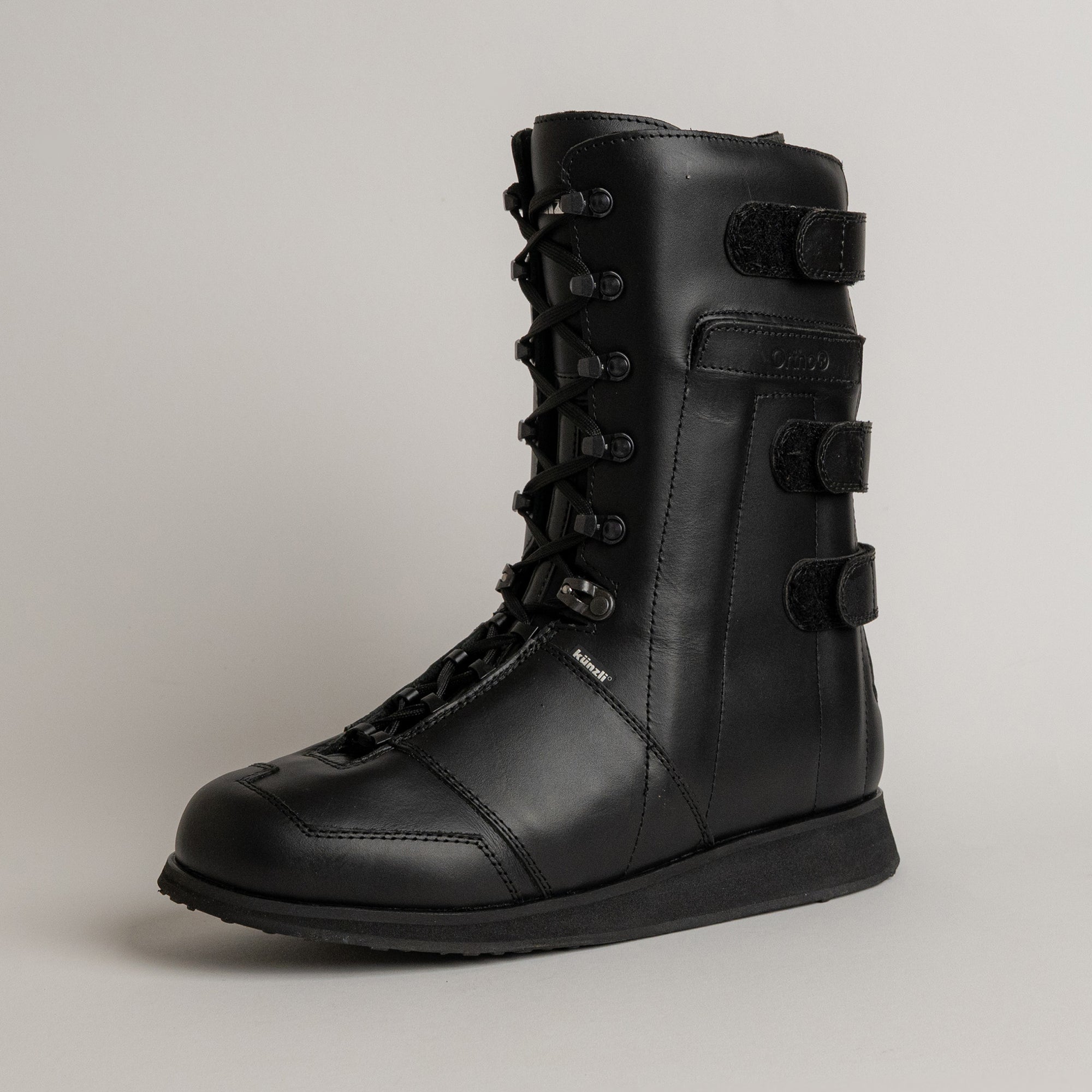 Schwarzer Lederstiefel von Kuenzli Schuhe mit Schnürung und Klettverschlüssen, ideal für Outdoor-Aktivitäten.