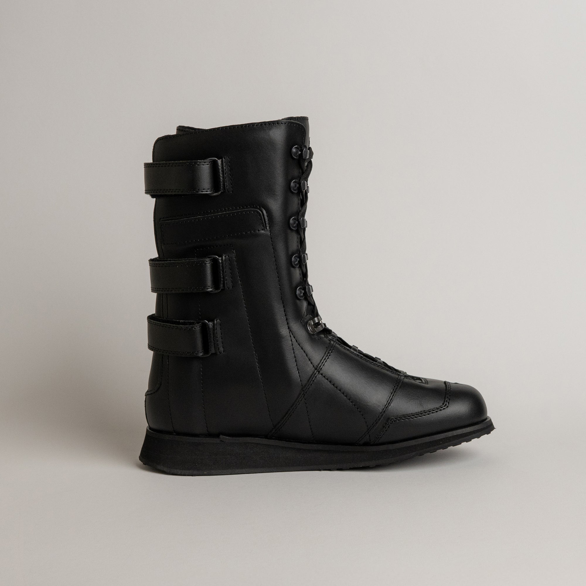 Schwarzer Lederstiefel von Kuenzli Schuhe mit Schnürung und Klettverschlüssen, ideal für Outdoor-Aktivitäten.