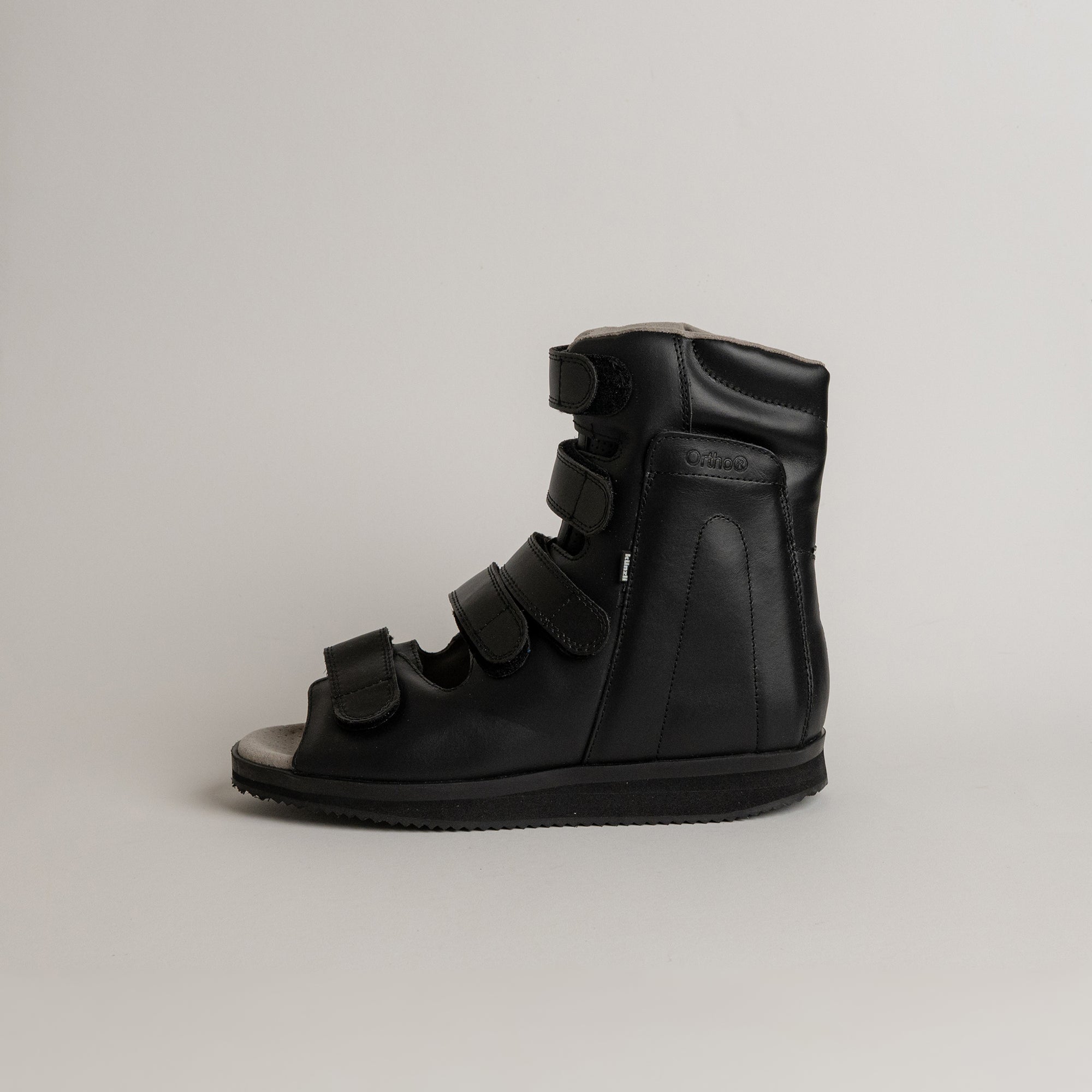 Schwarzer orthopädischer Schuh von Kuenzli Schuhe mit Klettverschlüssen, seitlich fotografiert.