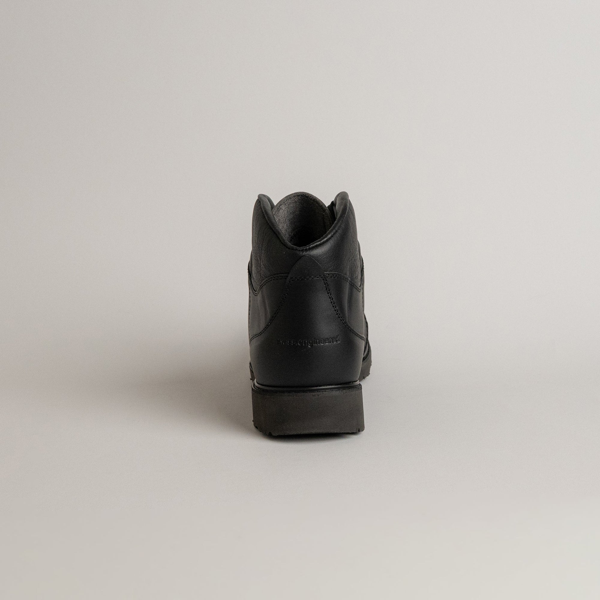 Schwarzer Lederschuh von Kuenzli Schuhe, Rückansicht, auf hellem Hintergrund fotografiert.