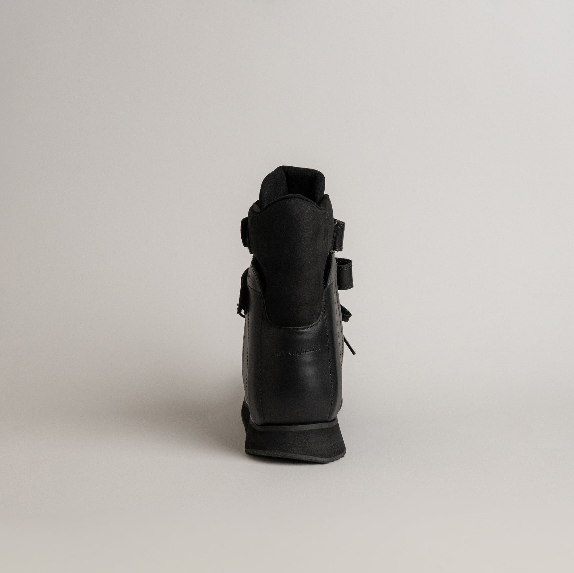 Ein schwarzer orthopädischer Schuh von Kuenzli Schuhe auf grauem Hintergrund.