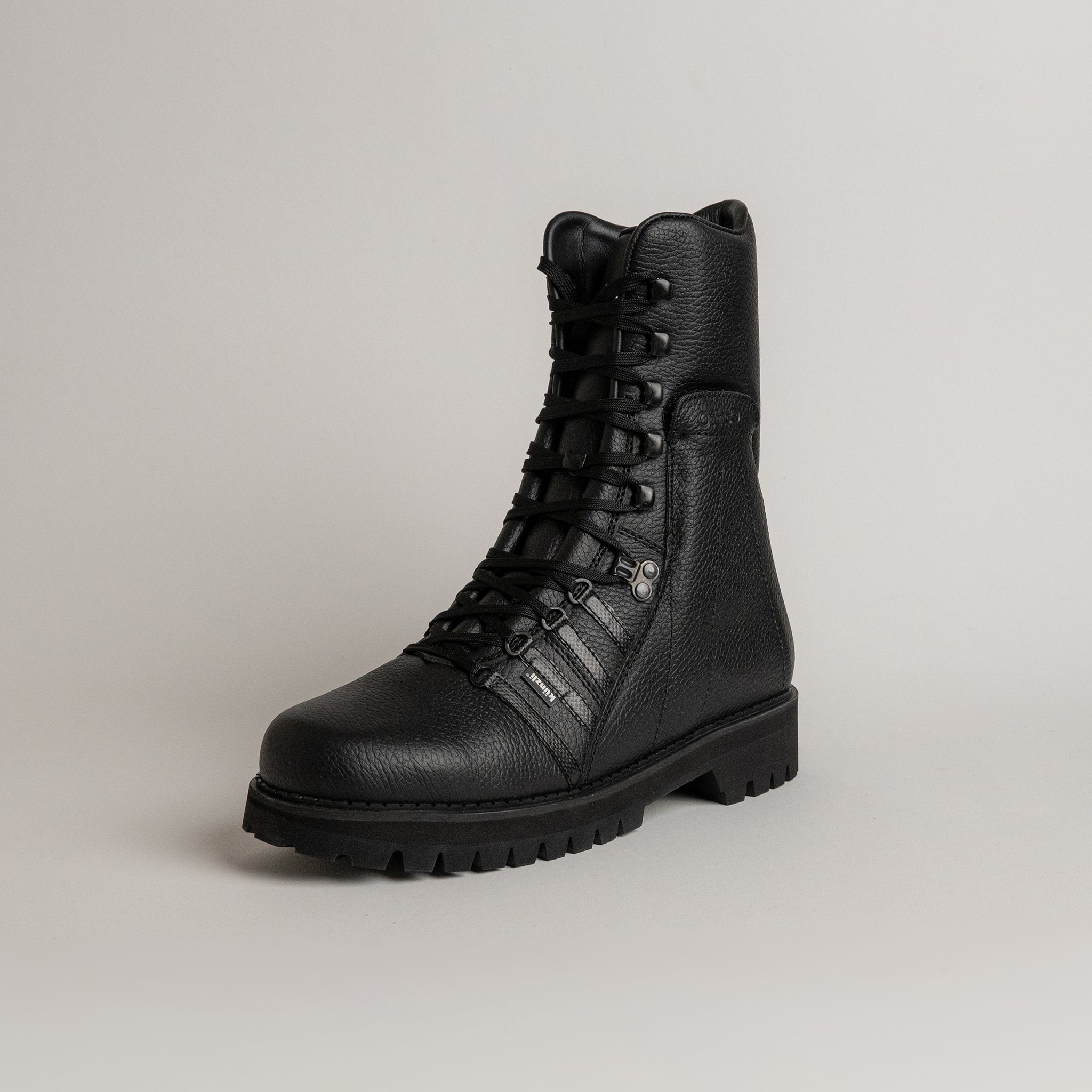 Schwarzer Lederstiefel von Kuenzli Schuhe mit robuster Sohle auf grauem Hintergrund.