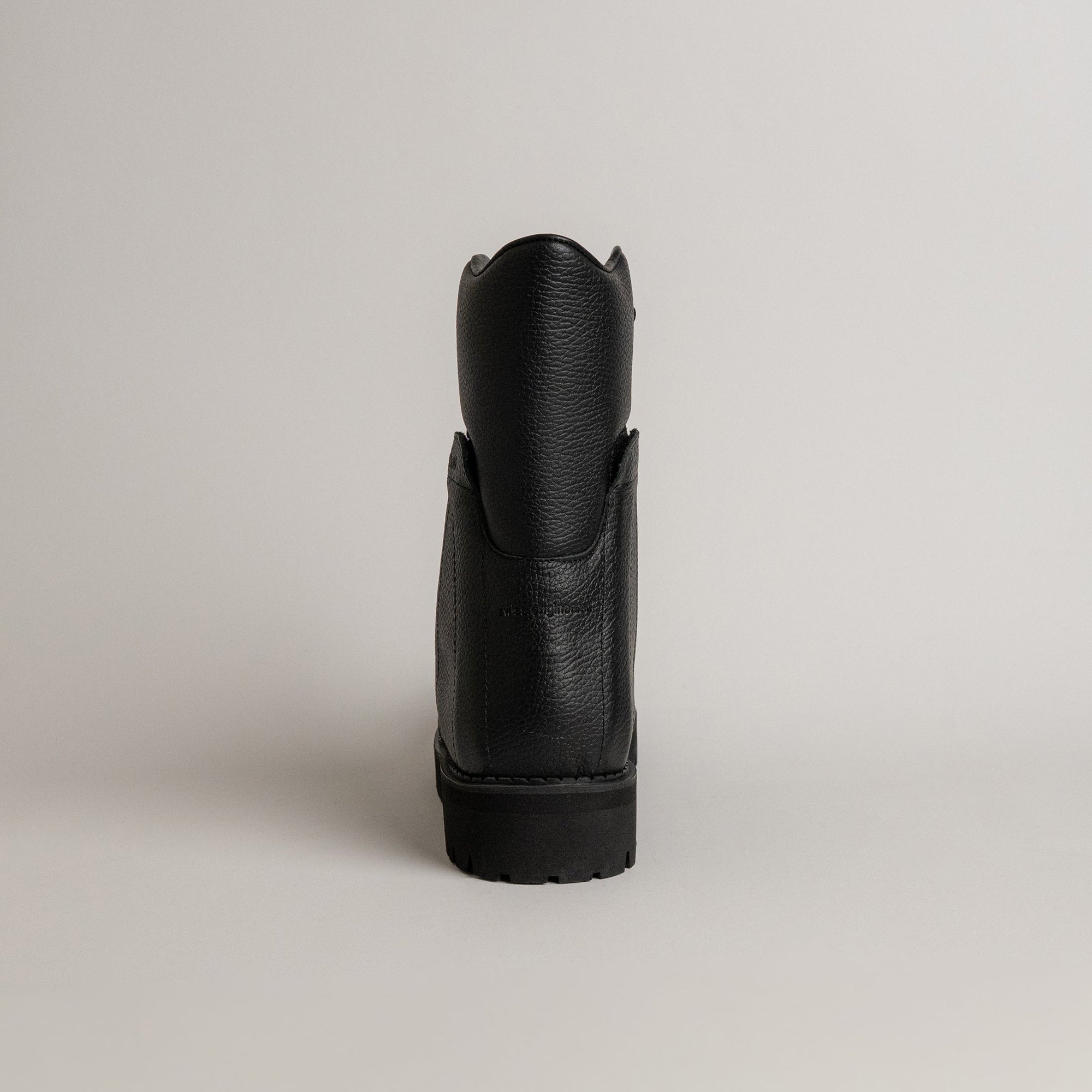 Schwarzer Lederschuh von Kuenzli Schuhe, Rückansicht, auf hellem Hintergrund.