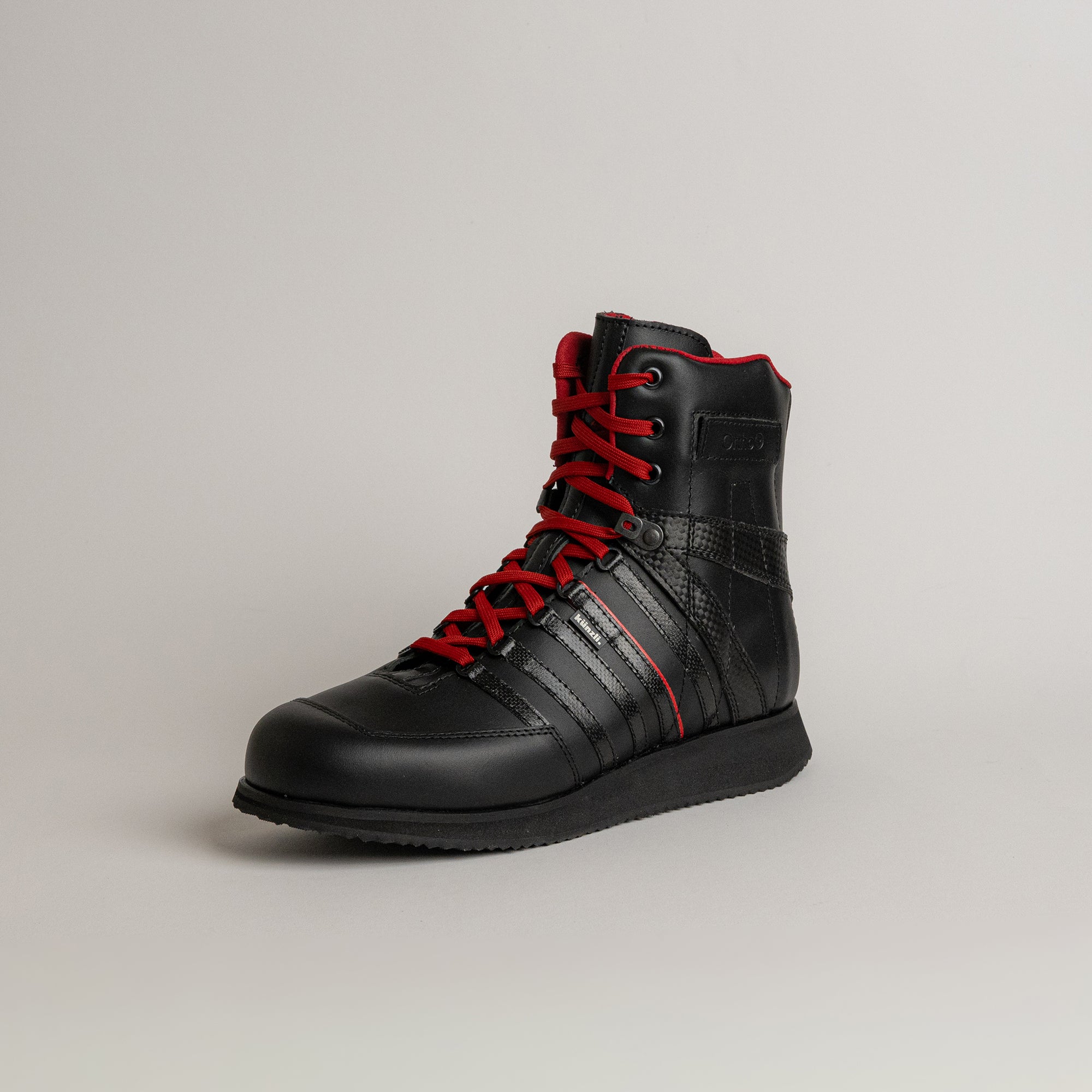 Schwarzer Lederstiefel mit roten Schnürsenkeln von Kuenzli Schuhe, ideal für Outdoor-Aktivitäten.