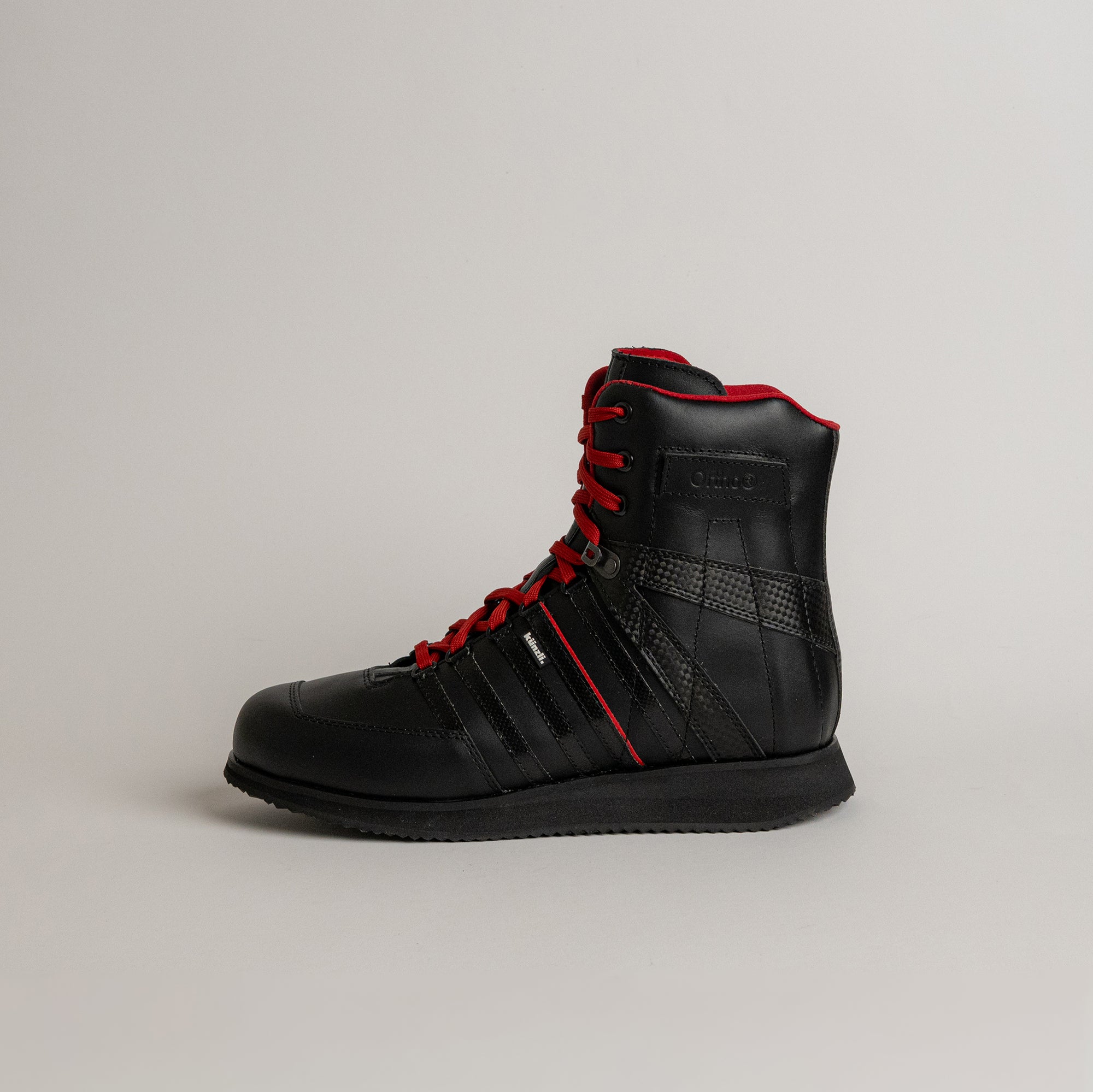 Schwarzer Kuenzli Schuh mit roten Schnürsenkeln, ideal für Outdoor-Aktivitäten und Waldtraining.