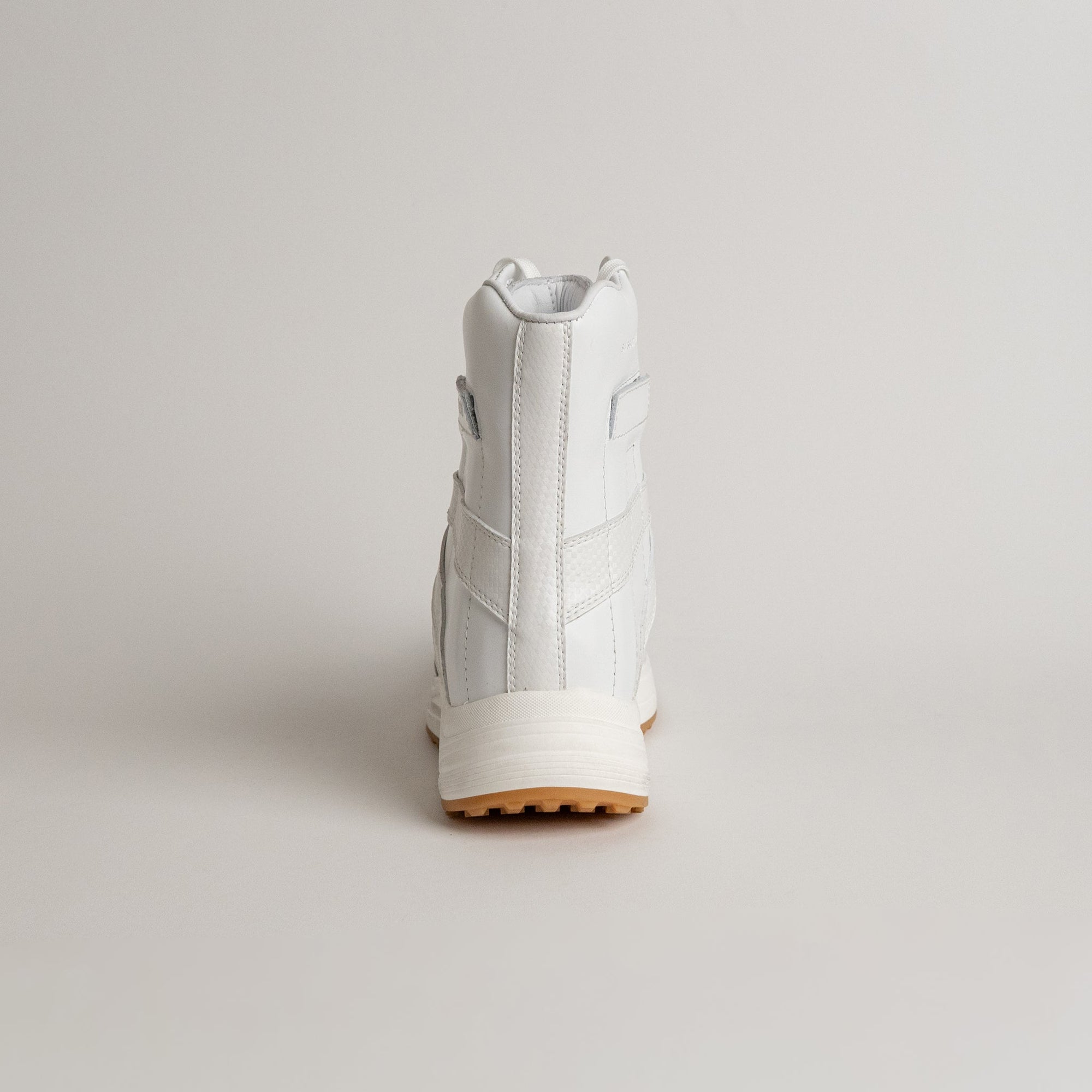 Ein weißer Kuenzli Schuh aus Leder, von hinten fotografiert, auf hellem Hintergrund.