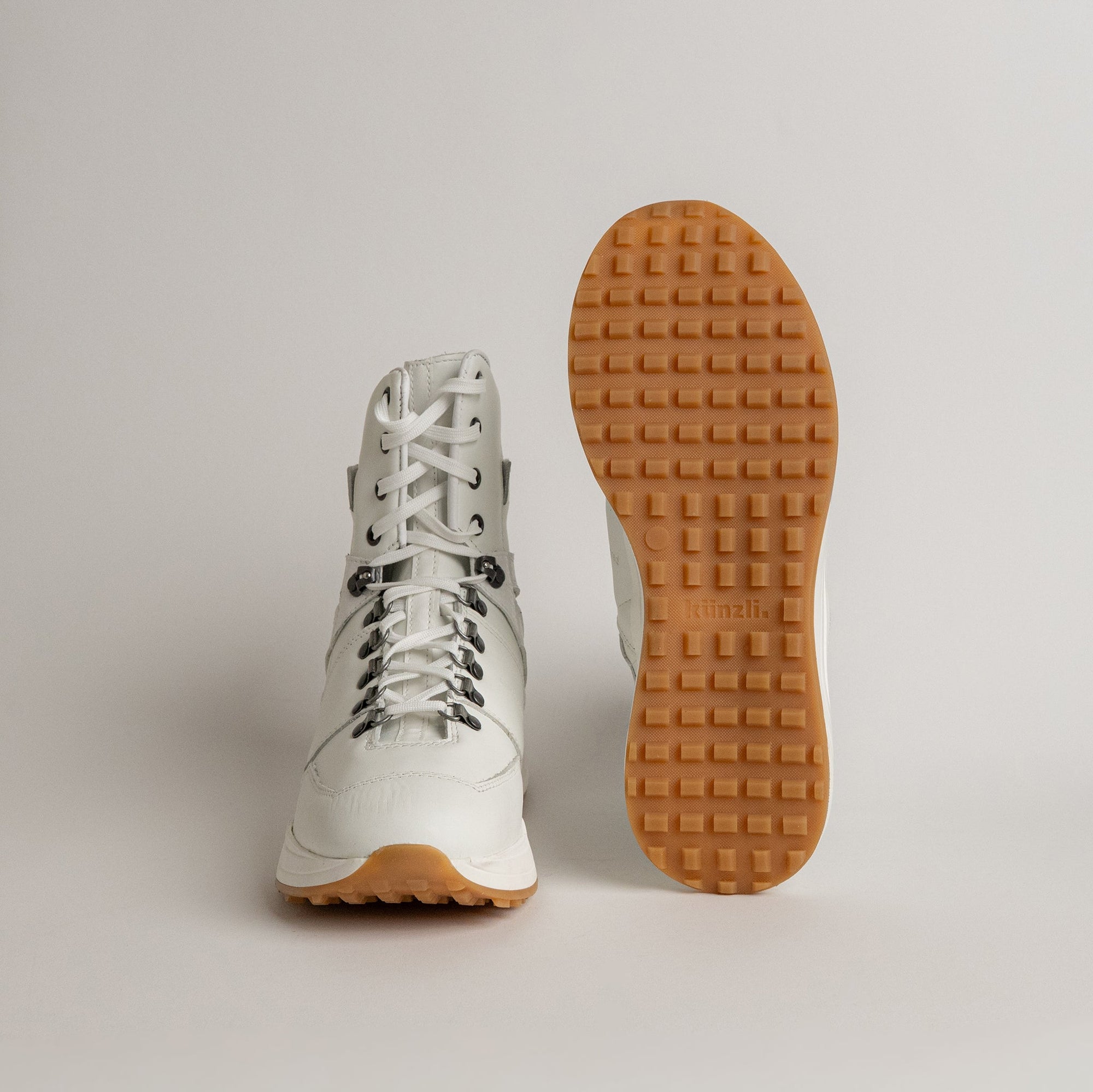 Ein weißer Kuenzli Schuh mit Profilsohle, ideal für Outdoor-Aktivitäten.