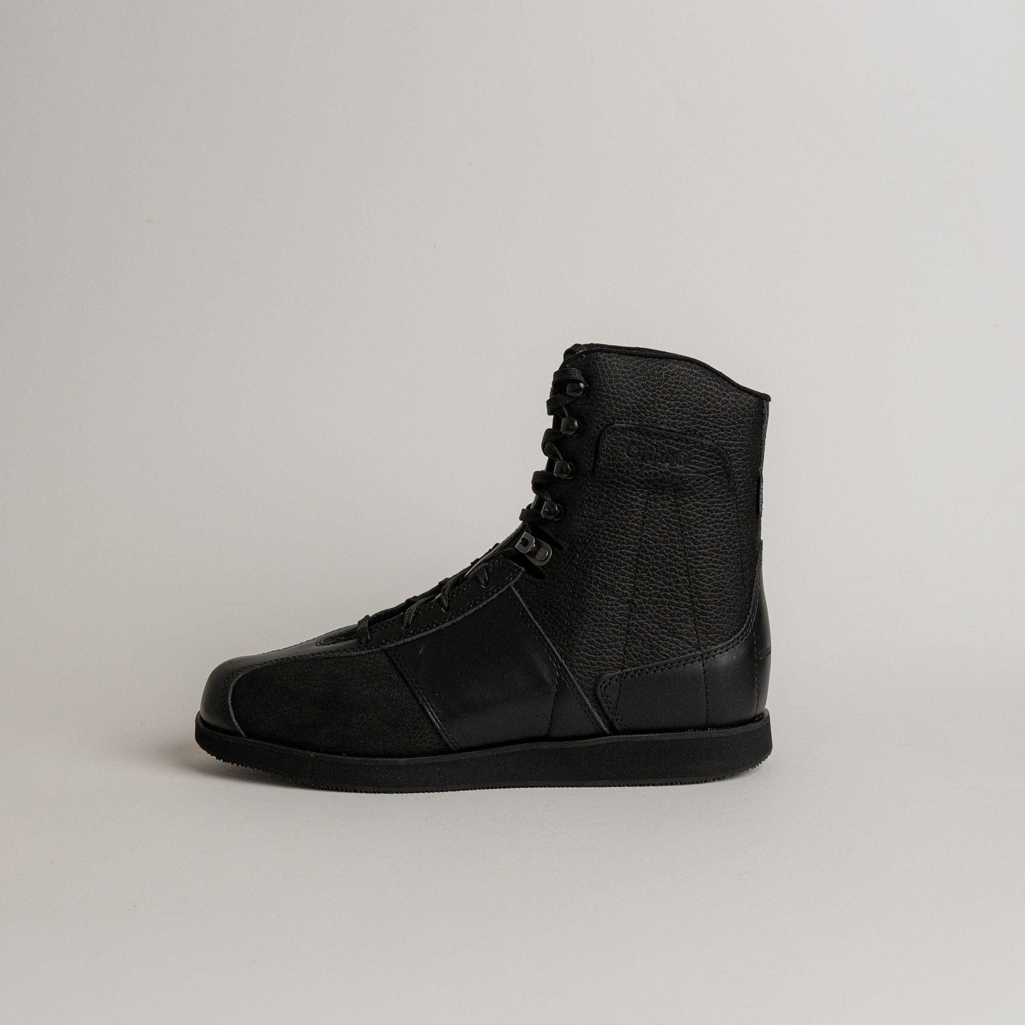 Schwarzer Lederstiefel von Kuenzli Schuhe, seitlich fotografiert auf neutralem Hintergrund.