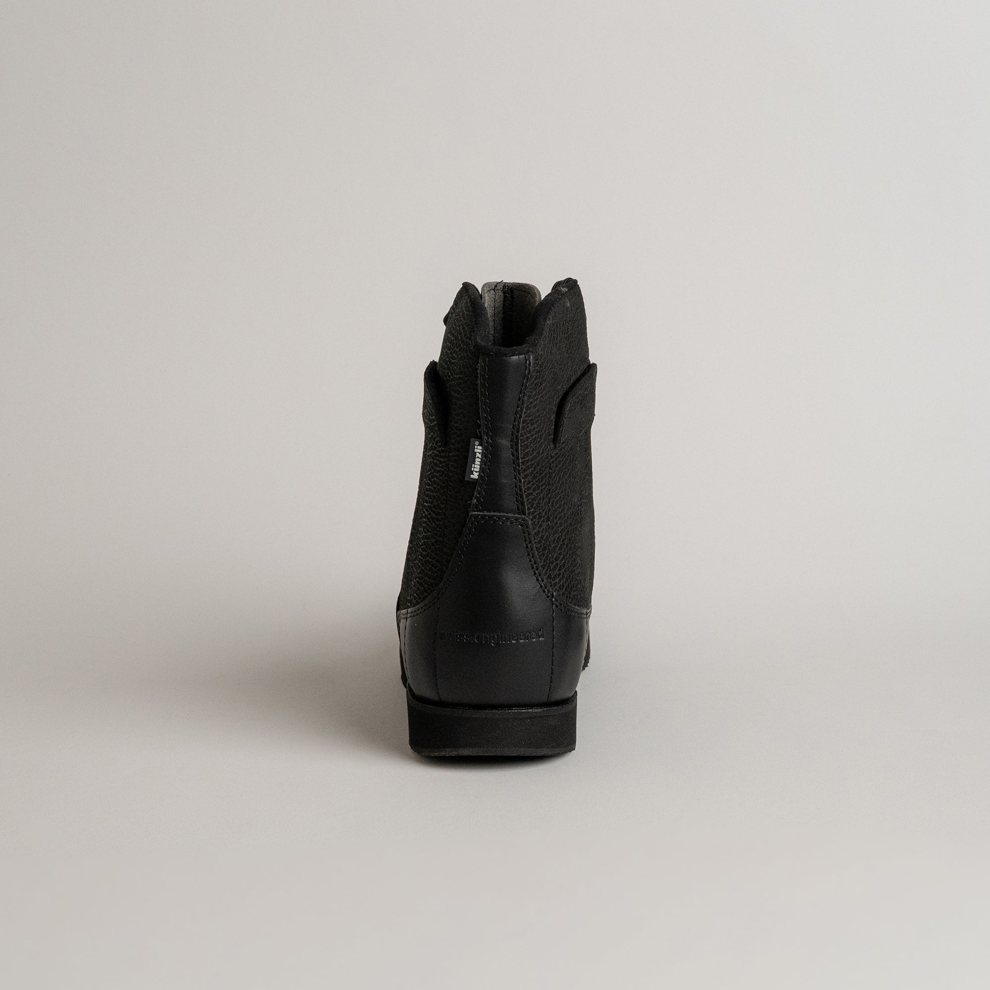 Schwarzer Lederstiefel von Kuenzli Schuhe, Rückansicht, auf neutralem Hintergrund.