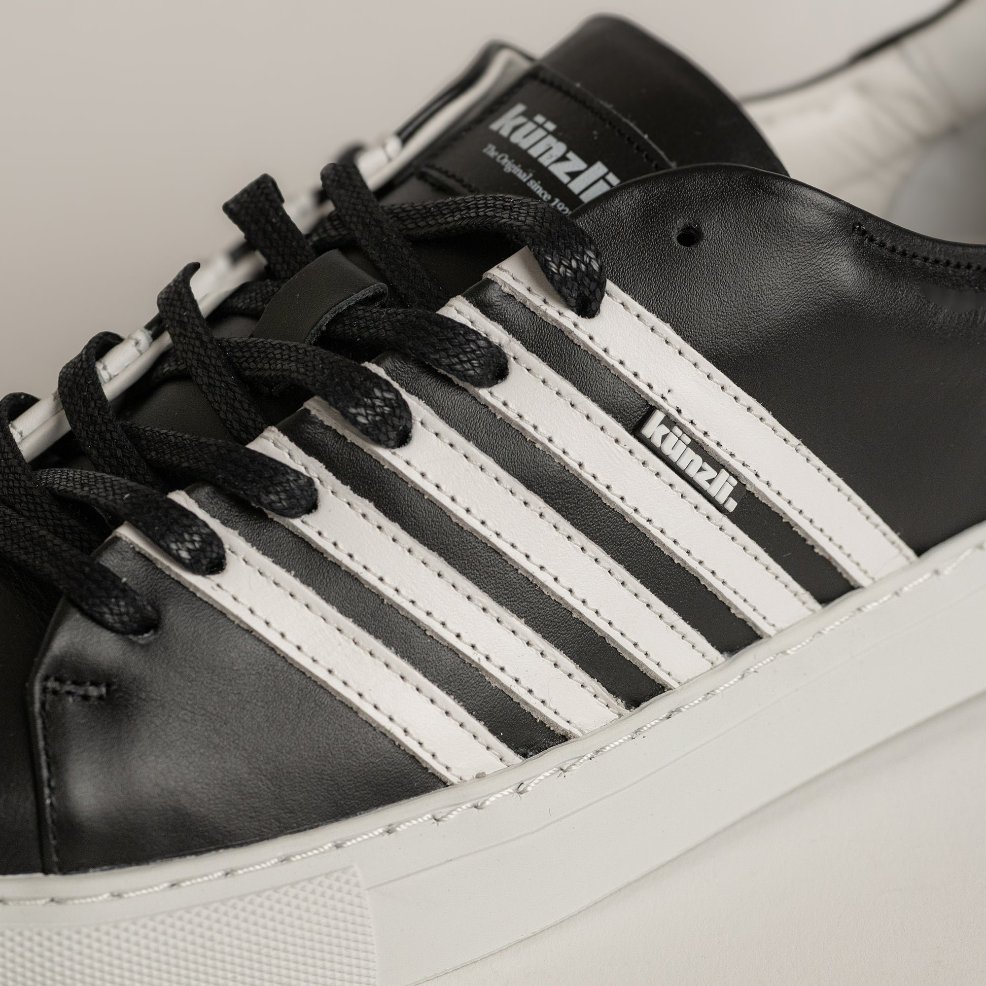 Schwarzer und weißer Lederschuh von Kuenzli Schuhe mit markanten Streifen.