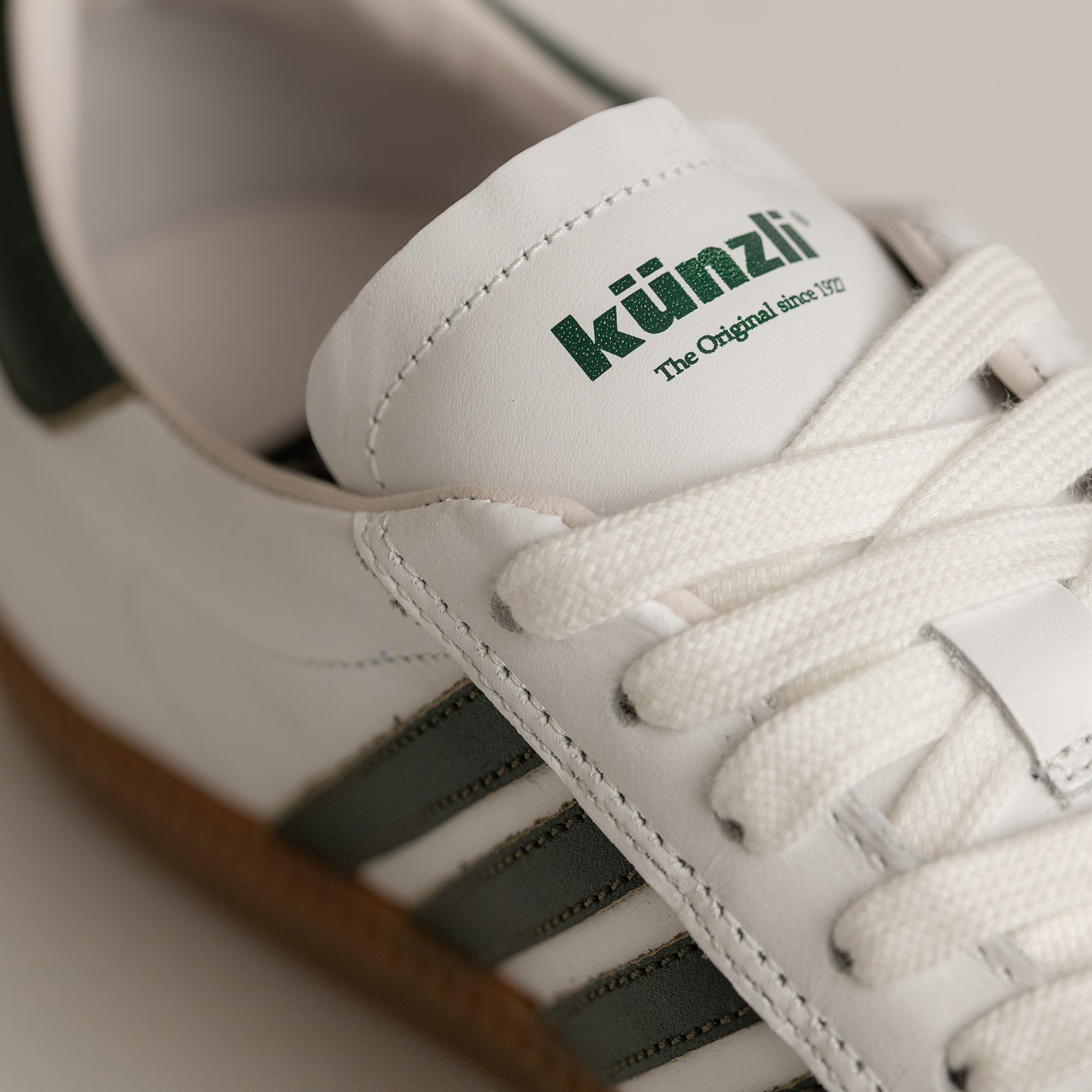 Weißer Kuenzli Schuh mit grünen Streifen und Schnürsenkeln aus Leder.