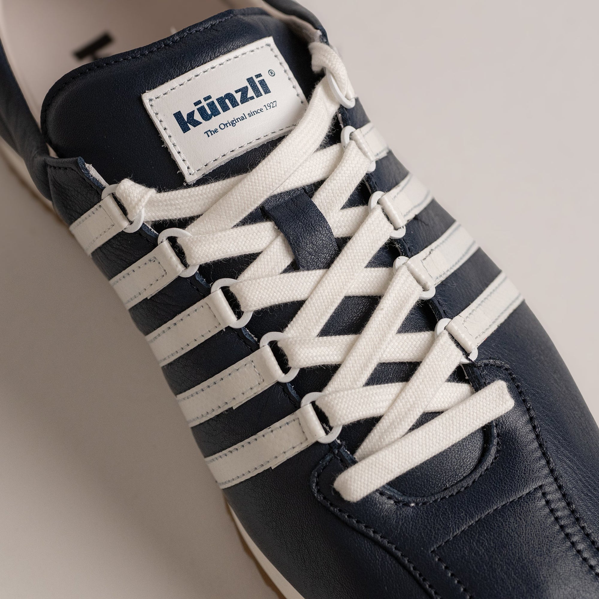 Ein Kuenzli Schuhe Sneaker in Blau-Weiß mit markanten weißen Schnürsenkeln.