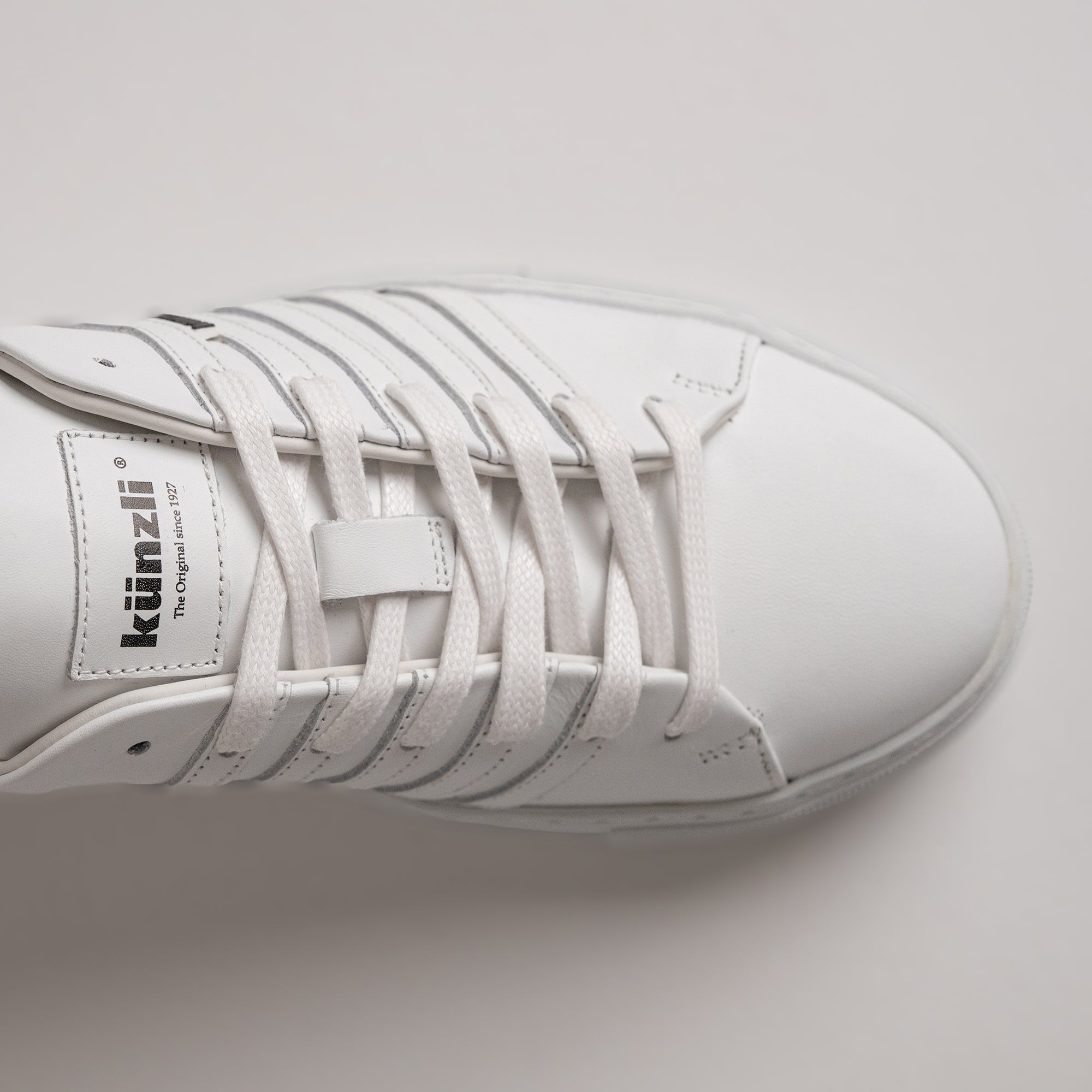 Weißer Ledersneaker von Kuenzli Schuhe mit Schnürsenkeln, ideal für sportliche Aktivitäten.