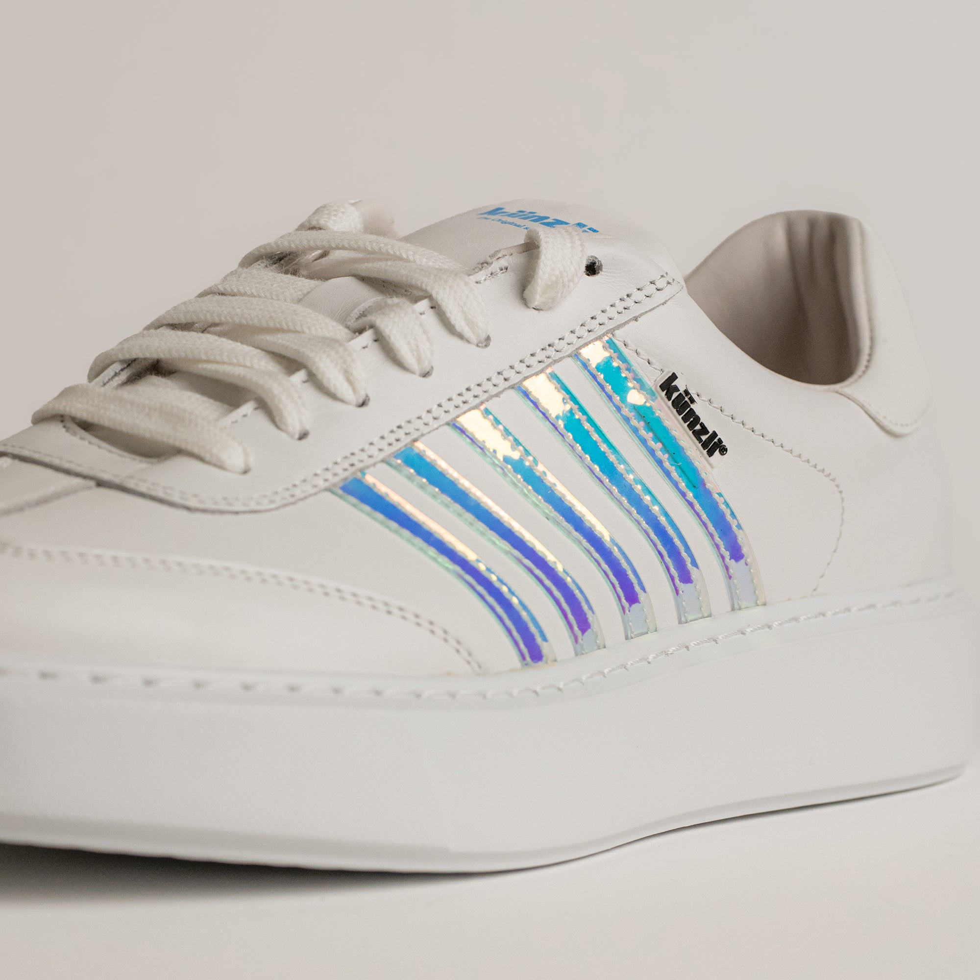 Weißer Kuenzli Schuh mit schimmernden Streifen, ideal für modische Freizeitaktivitäten.