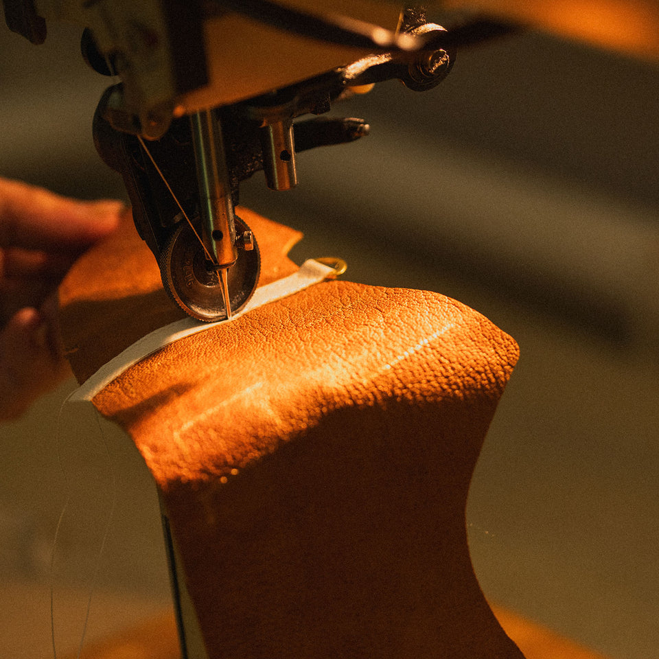 Nähmaschine bearbeitet braunes Leder für Kuenzli Schuhe in Handarbeit.