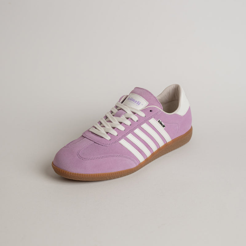 Lila Turnschuh von Kuenzli Schuhe mit weißen Streifen auf hellem Hintergrund.