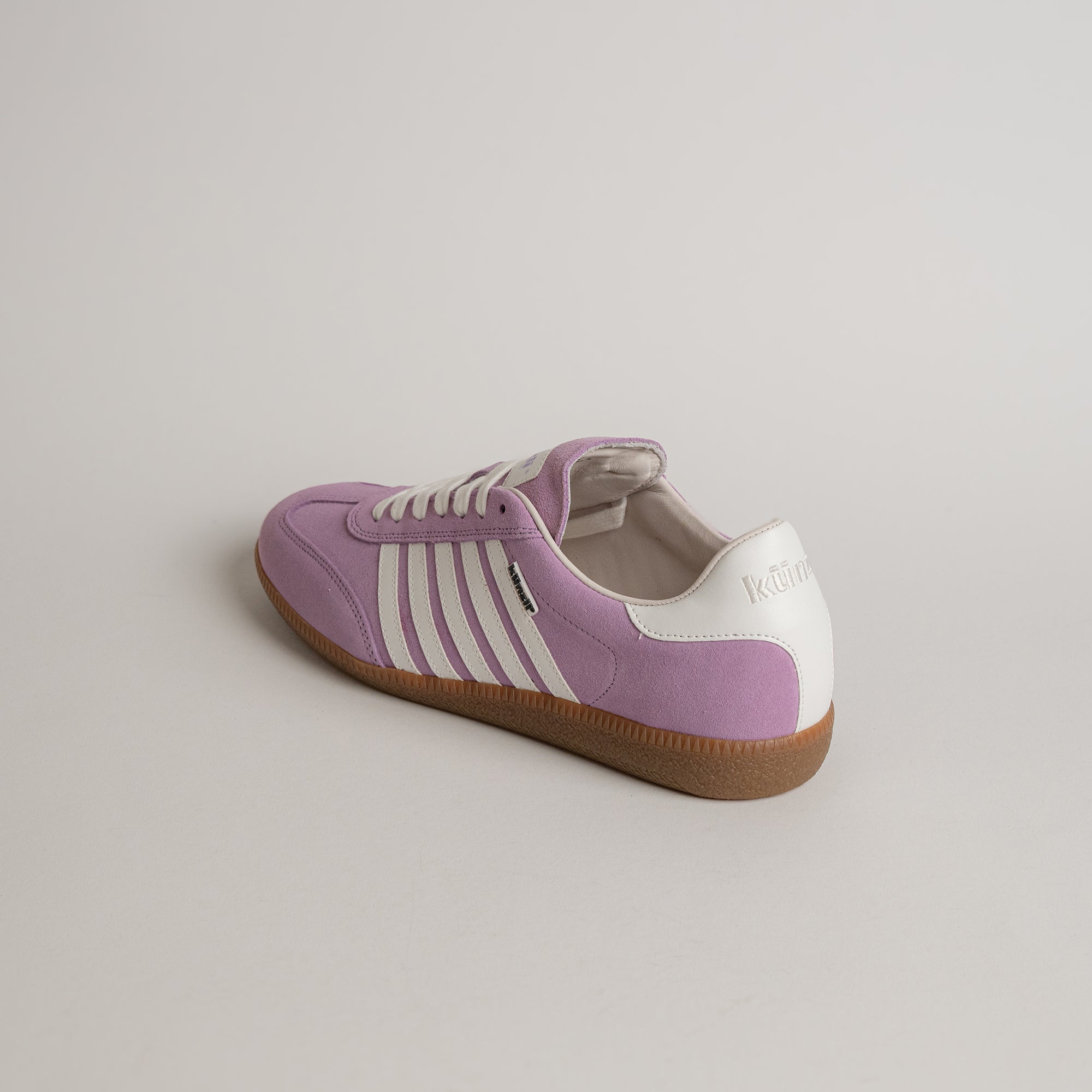 Lila-weißer Sneaker von Kuenzli Schuhe auf hellem Hintergrund, aus Wildleder.