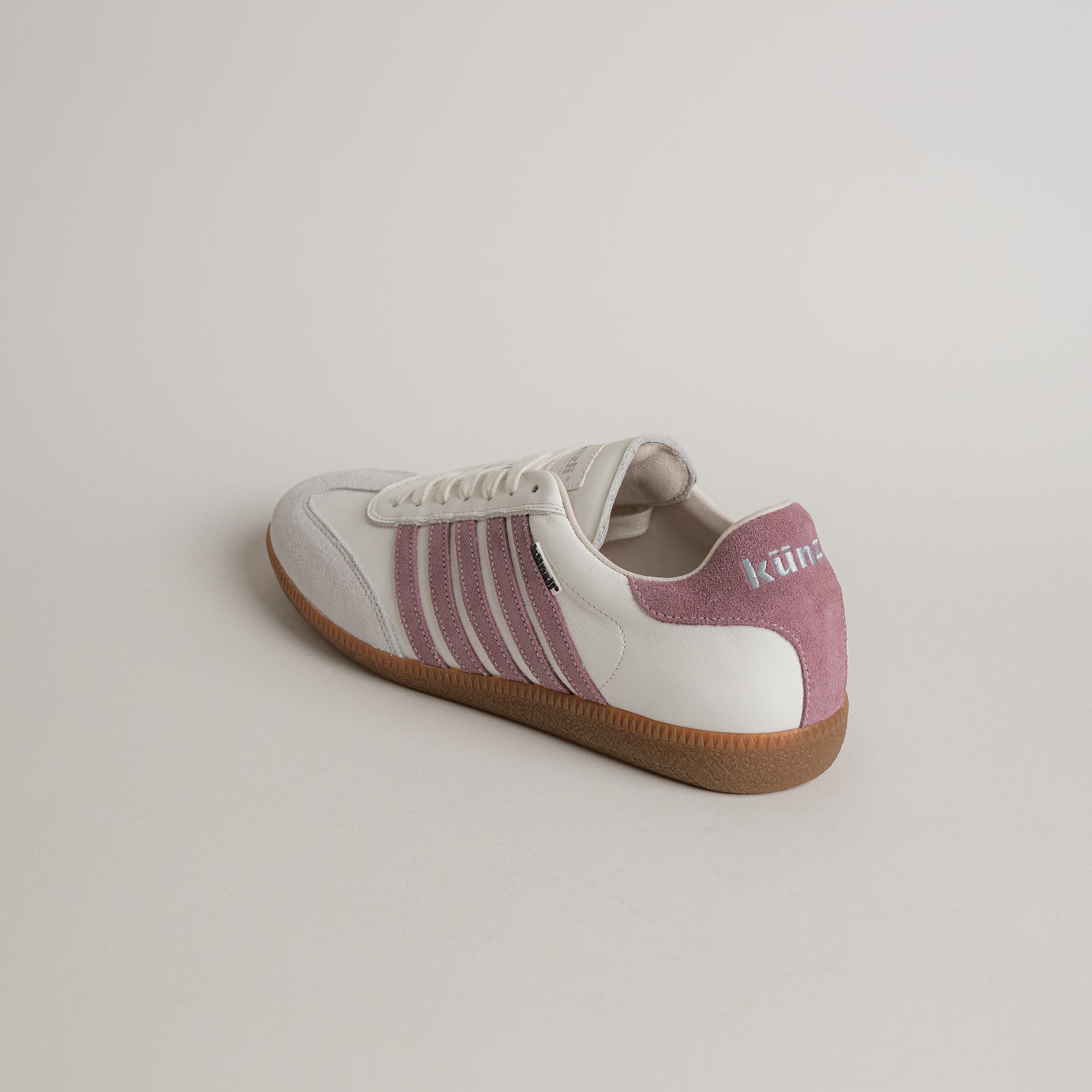 Weißer Sneaker mit rosa Streifen von Kuenzli Schuhe auf hellem Hintergrund.