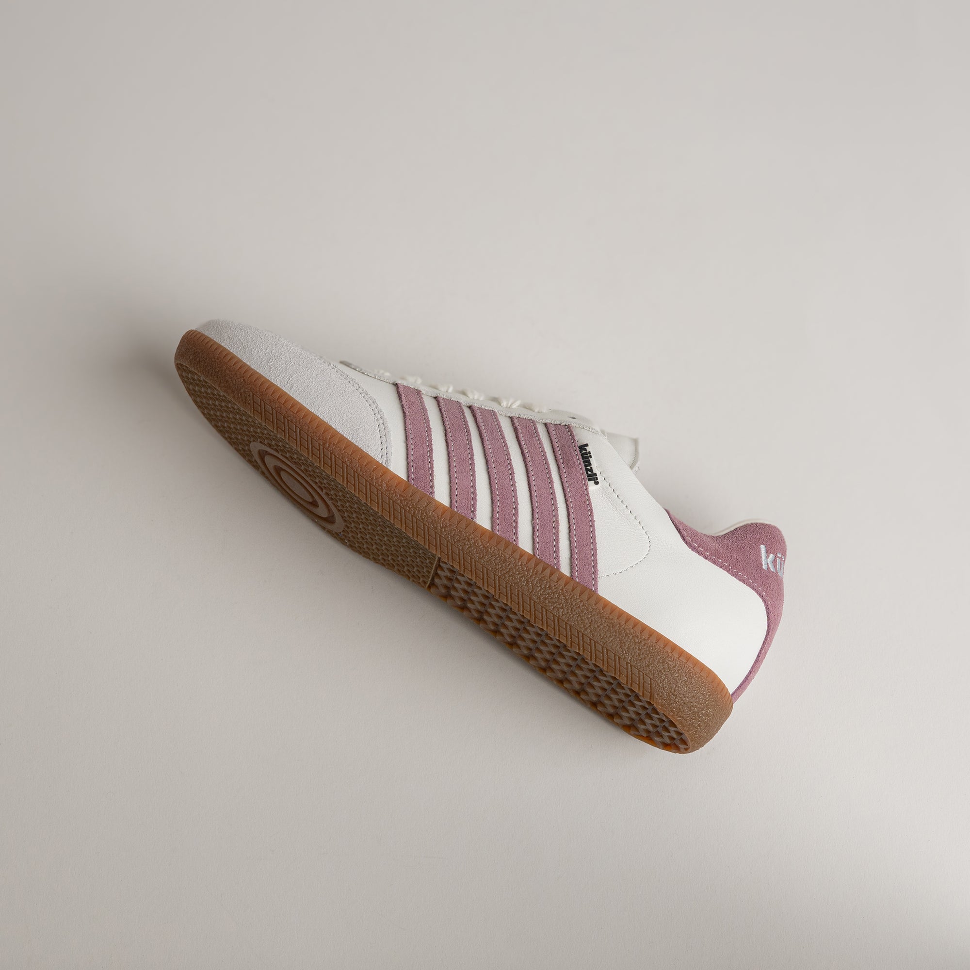 Weißer Kuenzli Schuh mit rosa Streifen und brauner Sohle auf hellem Hintergrund.