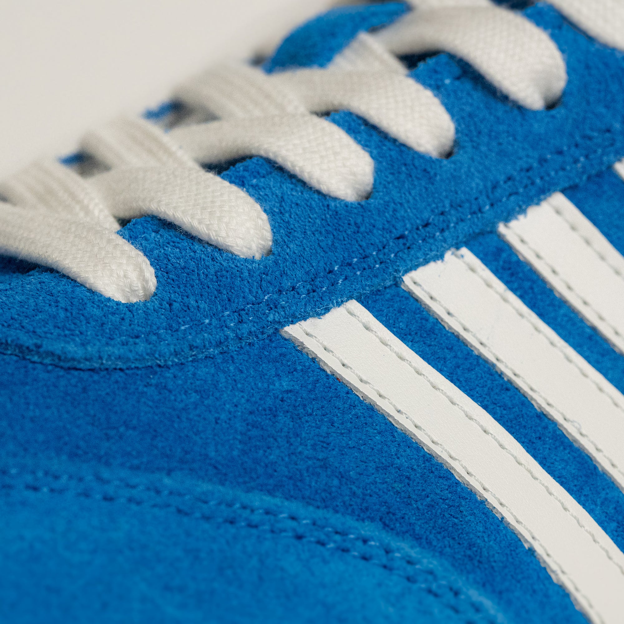 Blauer Wildlederschuh mit weißen Streifen und Schnürsenkeln von Kuenzli Schuhe.