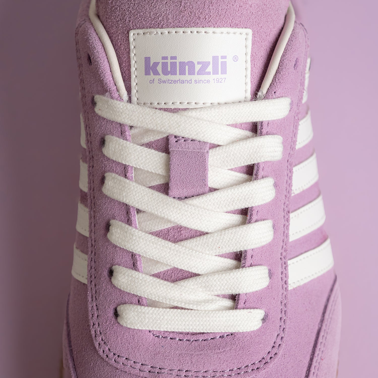Lila Wildleder-Sneaker von Kuenzli Schuhe mit weißen Schnürsenkeln und Streifen.